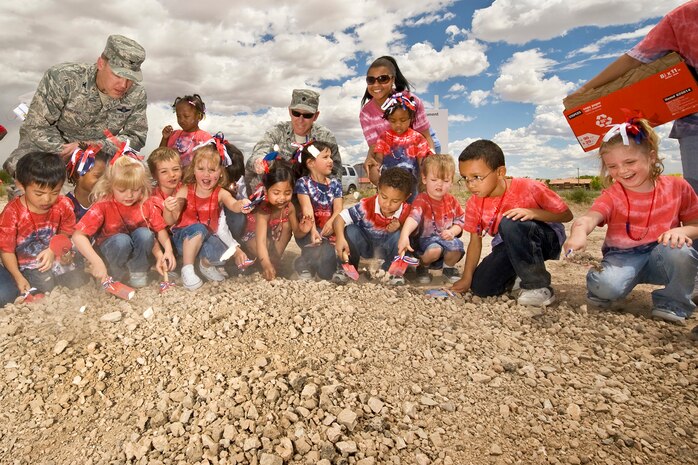 NELLIS AIR FORCE BASE, Nev.- Col. Steve Garland, 99th Air Base Wing commander(left), Lt. Col. Jon Heileman, 99th Force Support Squadron commander, and children from the Huggi Bears class break ground for the new Nellis Child Development Centers, May 12.  (U.S. Air Force photo by Lawrence R. Crespo)
