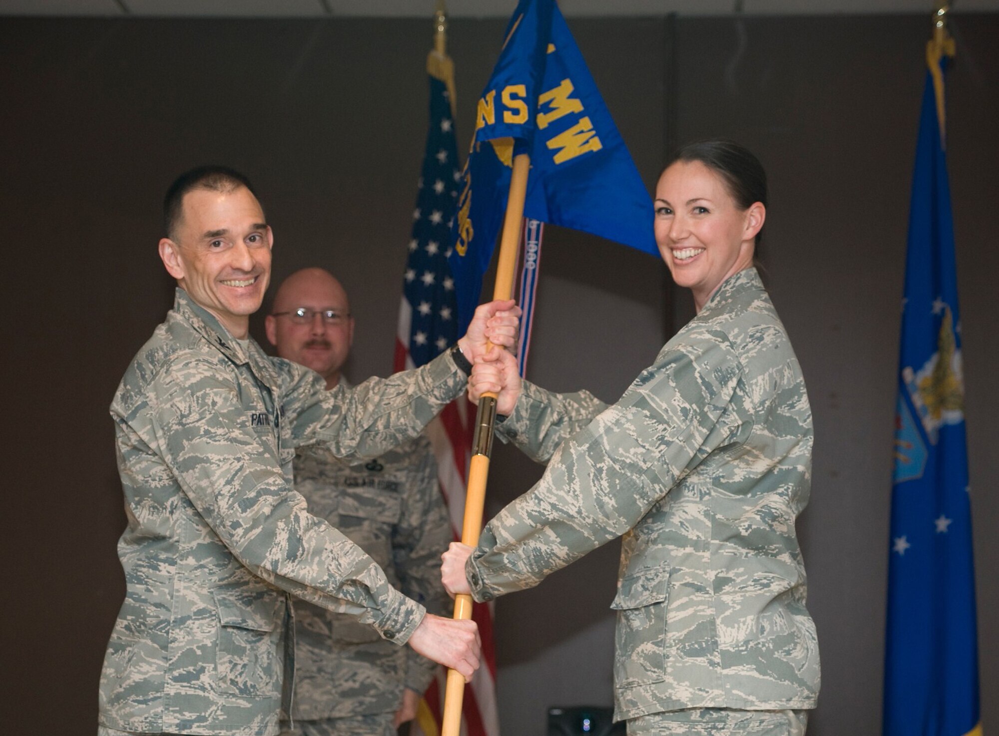 Col. John Patricola, 341st Mission Support Group commander, passes the 341st Contracting Squadron flag to Maj. Jill Boese, 341st CONS commander, at the activation ceremony May 7. After the deactivation of the 341st Comptroller Contracting Squadron, the Contracting and Comptroller Squadron’s were activated as two separate units. (U.S. Air Force photo/Beau Wade)