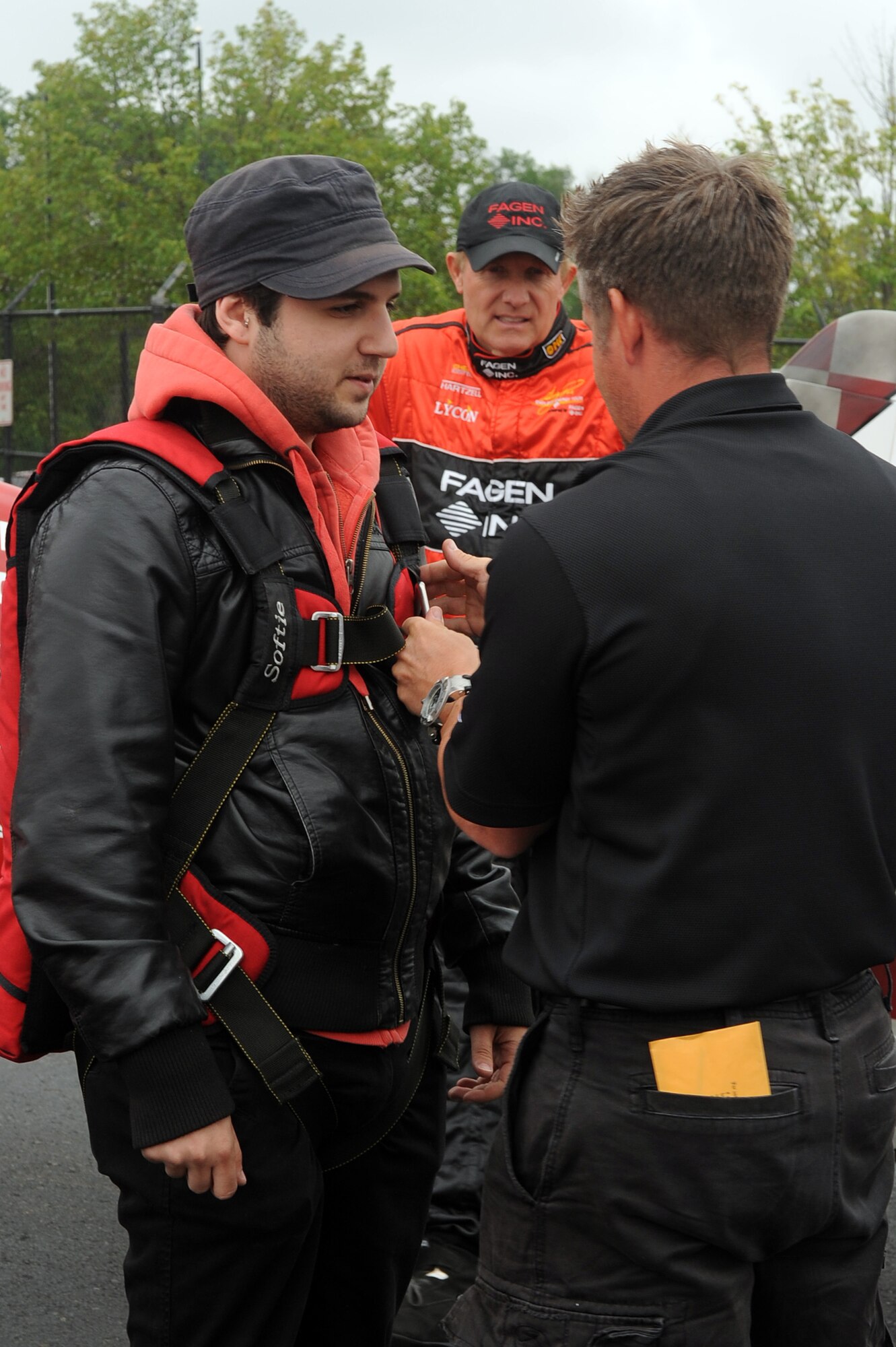 Samy K (left), Hot 99.5 morning talk show co-host for “The Kane Show” on WIHT-FM Washington D.C., gets strapped into a flight harness by Dax Wanlessin (right), Vice President of operations for Greg Poe (center) performances, at Manassas Regional Airport, Manassas, Va., May 13. Samy flew with Greg Poe as a special media guest for the Joint Service Open House May 14-16 at Joint Base Andrews.(U.S. Air Force photo by Senior Airman Melissa V. Brownstein)