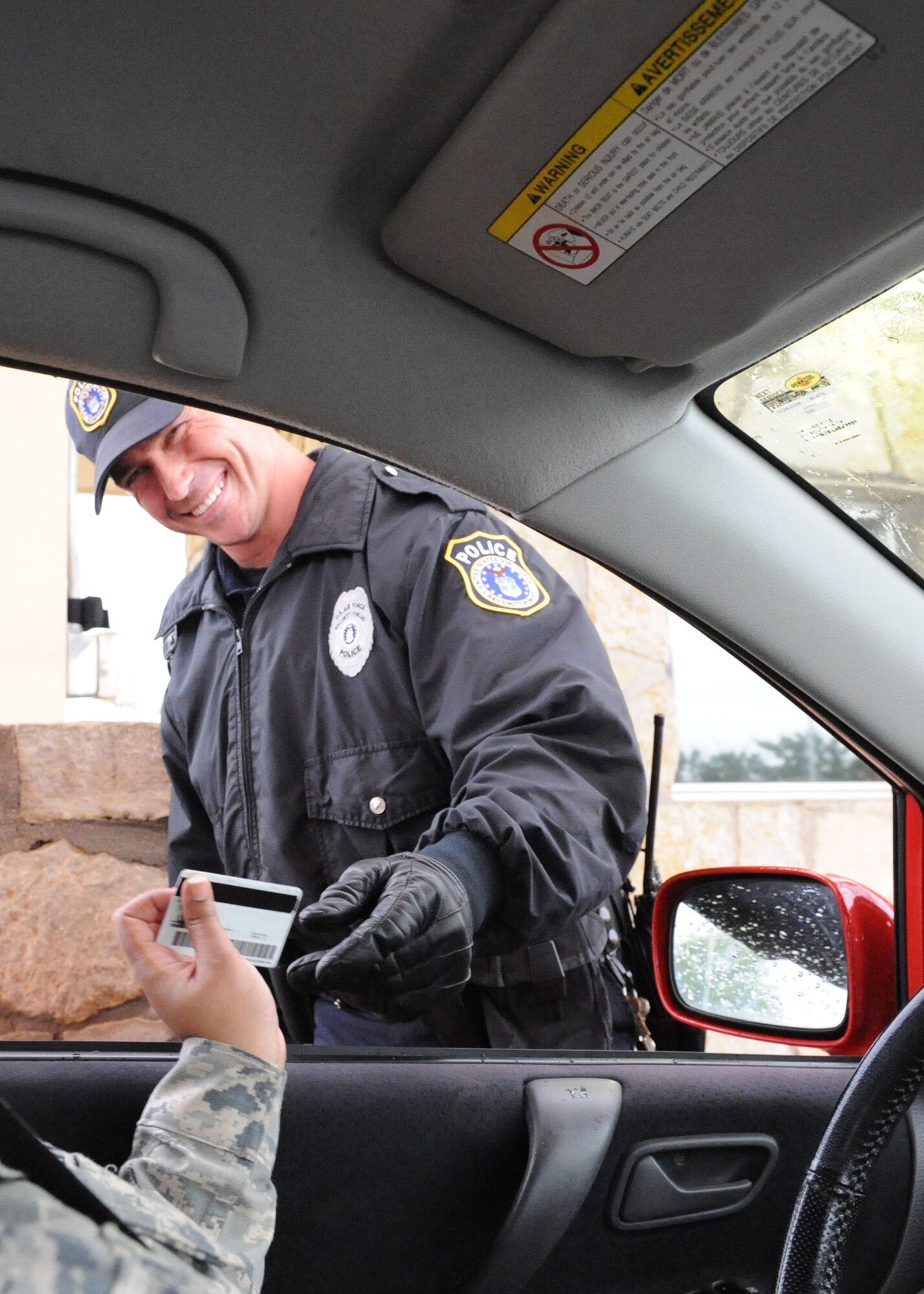 DYESS AIR FORCE BASE, Texas—Adam Keidl Jr., U.S. Protect employee, checks an individual’s identification card May 13 at the front gate here. Employees from the U.S. Protect agency work with the 7th Security Forces Squadron securing the base 24/7 through rain, snow, heat and all kinds of weather. (U.S Air Force photo/ Airman 1st Class Shannon Hall)