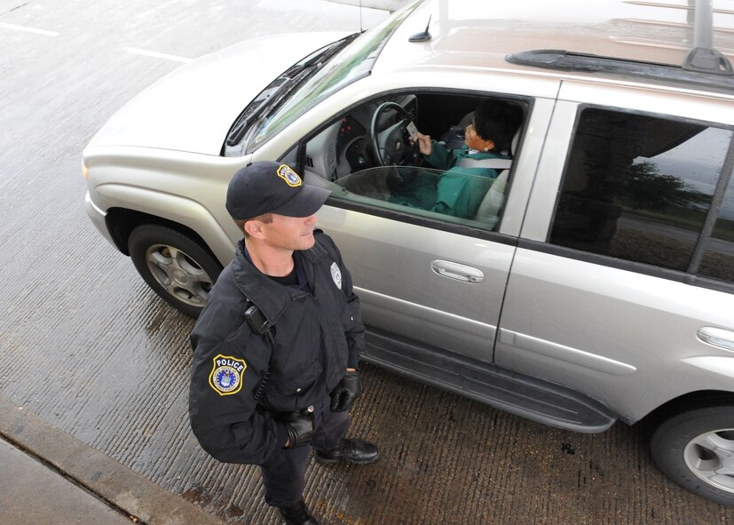 DYESS AIR FORCE BASE, Texas—Adam Keidl Jr., U.S. Protect employee, stands guard and checks individual’s identification cards May 13 at the front gate here. Employees from the U.S. Protect agency work with the 7th Security Forces Squadron securing the base 24/7 through rain, snow, heat and all kinds of weather. (U.S Air Force photo/ Airman 1st Class Shannon Hall)
