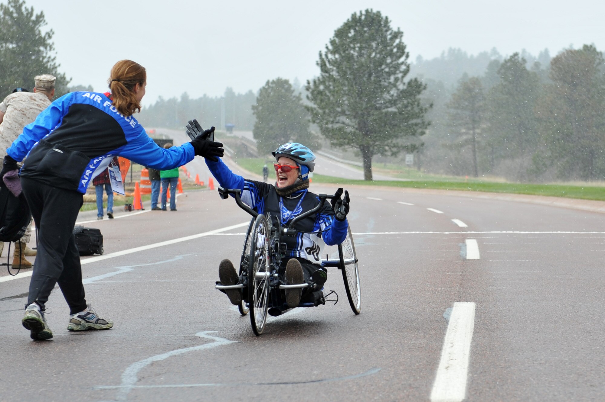 Jeanne Goldy-Sanitate receives a high five from Air Force head coach Cami Stock after completing the 10-kilometer hand cyle start bike race for the inaugural Warrior Games May 13, 2010, at the U.S. Air Force Academy in Colorado Springs, Colo.  Goldy-Sanitate is one of some 200 disabled veterans participating in the Paralympic-style competition May 10 through 14. (U.S. Air Force photo/Staff Sgt. Desiree N. Palacios)