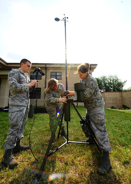 DYESS AIR FORCE BASE, Texas – Staff Sgt. James Ellis (center), Senior Airman Ann Winters (right) and Senior Airman Sara Wauer (left), 7th Operations Support Squadron weather forecasters, forecast the weather using a Tactical Meteorological Observing System (TMQ-53) near the flighline May 12 for upcoming storms here. This instrument detects wind direction, temperature, relative humidity, lightning, rain conditions, cloud depth and visibility. It also provides pilots weather patterns to help land aircraft in deployed locations. (U.S. Air Force photo/Senior Airman Stephen Reyes)