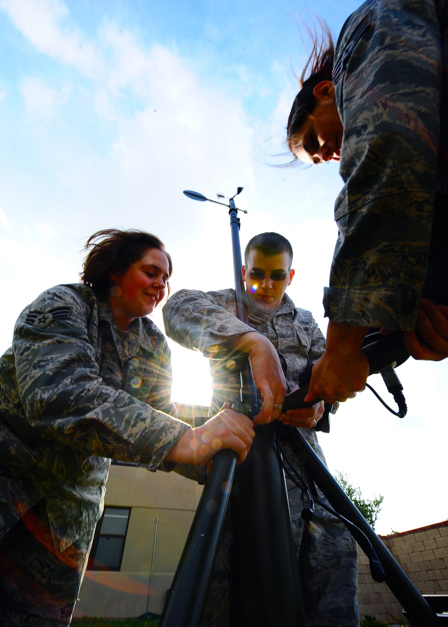 DYESS AIR FORCE BASE, Texas –Weather forecasters from the 7th Operations Support Squadron, Senior Airman Sara Wauer (center), Senior Airman Ann Winters (right) and Staff Sgt. James Ellis (left), assemble a Tactical Meteorological Observing System (TMQ-53) near the flightline May 12 for upcoming storms here. The TMQ-53 is used mostly in deployed locations providing pilots weather patterns to help land aircraft and detect wind direction, temperature, relative humidity, lightning, rain conditions, cloud depth and visibility. (U.S. Air Force photo/Senior Airman Stephen Reyes)