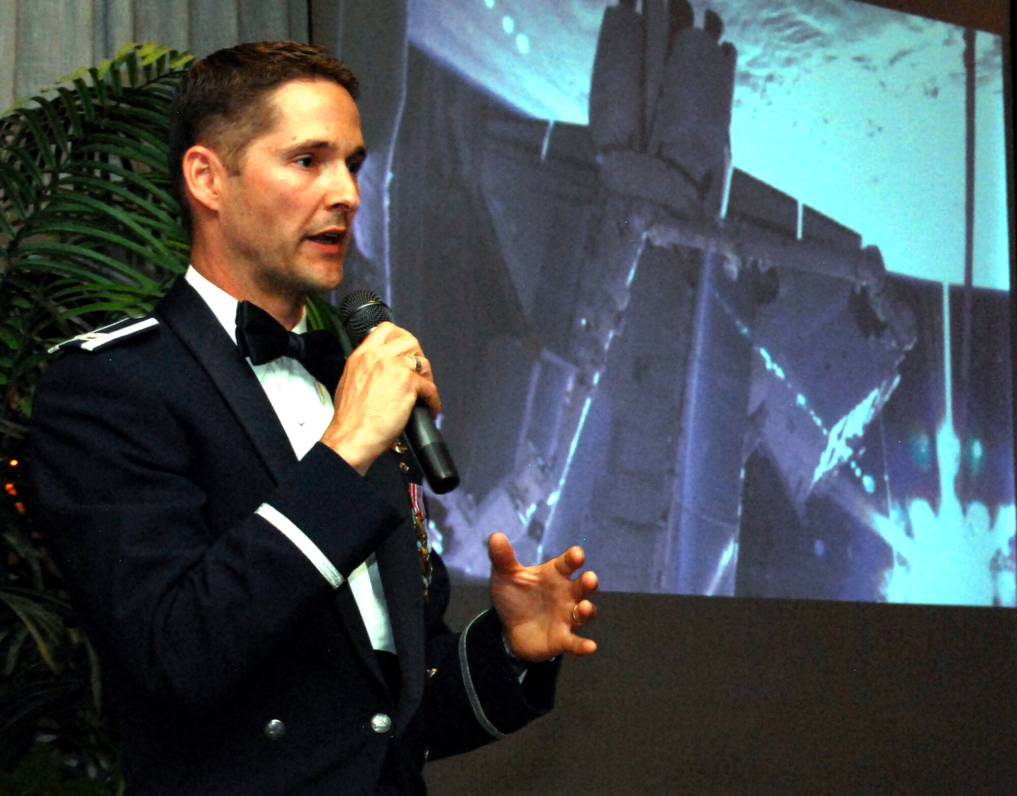 Astronaut Col. Jim Dutton narrates a video compilation of the STS-131 space shuttle mission May 7, 2010, during a Department of Astronautics dining-out at the Air Force Academy's Falcon Club. Colonel Dutton, a 1991 Academy graduate and astronautics major, was the pilot for the mission in April to install a robotics laboratory on the International Space Station. (U.S. Air Force photo/Staff Sgt. Don Branum)