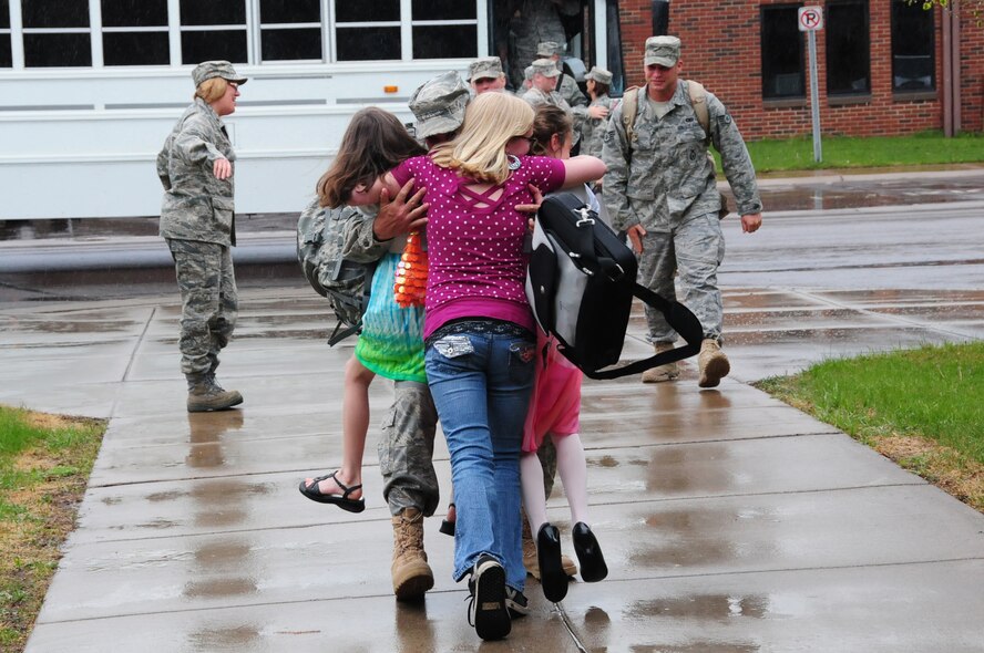 U.S. Air Force Senior Master Sgt. James Picconatto, 148th Fighter Wing Security Forces, embraces his three daughters as he arrives home at the Duluth, Minn., based Air National Guard base May 13, 2010. Approximately 35 Air National Guard members of the 148th Fighter Wing Security Forces Squadron returned to Duluth, Minn., after a 6-month deployment in southwest Asia. (U.S. Air Force photo by Master Sgt. Jason W. Rolfe/Released)