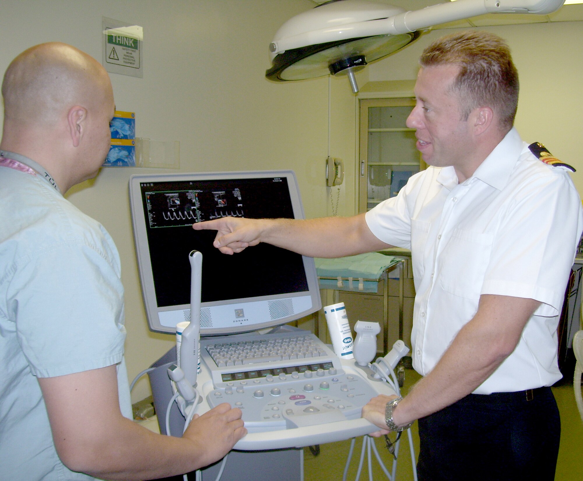 Royal Navy Lt. Commander Adam Stannard (right) discusses blood flow on an ultrasound machine with Mike Goedecke, biological lab assistant, in the Clinical Research building May 6, 2010, at Lackland Air Force Base, Texas. Commander Stannard, a fellow in the Academic Department of Military Surgery and Trauma at the Royal Centre for Defence Medicine in Birmingham, England, has joined a 59th Medical Wing research team for one year to investigate vascular surgery techniques.  (U.S. Air Force photo/Sue Campbell)