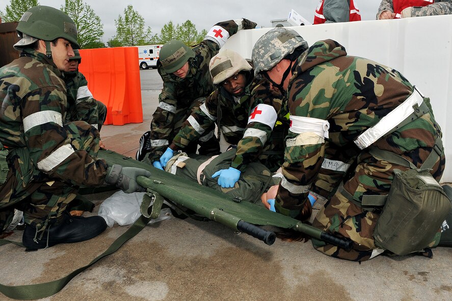 OFFUTT AIR FORCE BASE, Neb. -- Several members of the 55th Medical Group wait for the signal before lifting a wounded Airman during an Operational Readiness Exercise at Base X, a simulated deployed location here May 13. Members of the 55th Wing are currently participating in the exercise to test their combat skills and ability to effectively protect a deployed base from attack. U.S. Air Force Photo/Charles Haymond