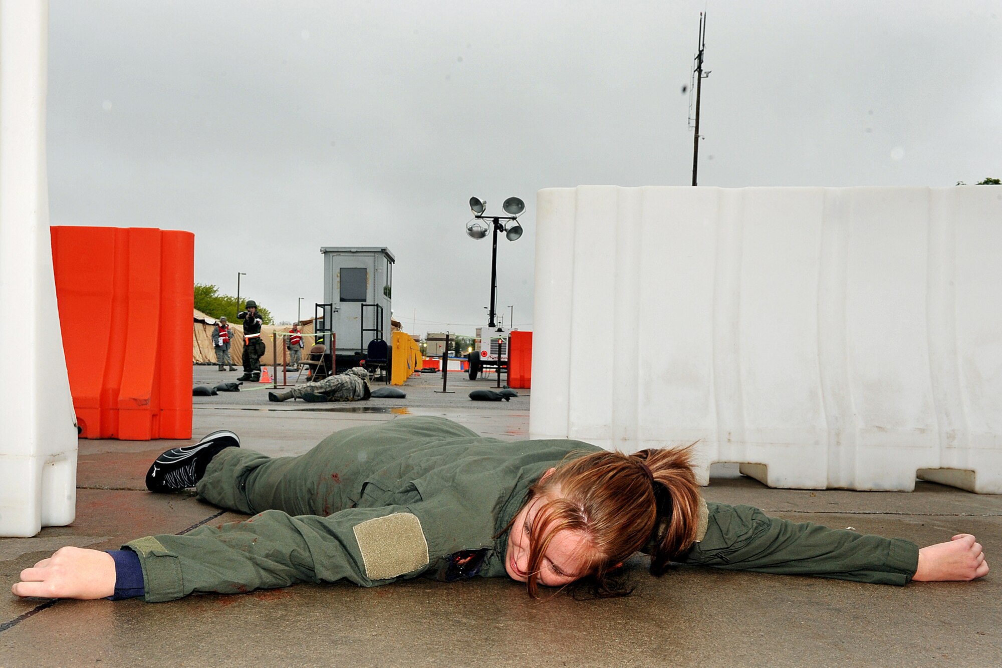 OFFUTT AIR FORCE BASE, Neb. -- Airman 1st Class Kimberly Shingle, 55th Communications Squadron, lies down on the ground at an entry control point while armed guards watch her during an Operational Readiness Exercise at Base X, a simulated deployed location here May 13. Members of the 55th Wing are currently participating in the exercise to test their combat skills and ability to effectively protect a deployed base from attack. U.S. Air Force Photo/Charles Haymond