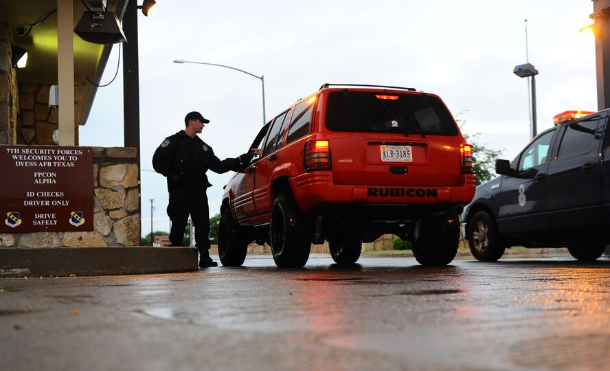 DYESS AIR FORCE BASE, Texas—Adam Keidl, U.S. Protect employee, performs an identification check May 13, on a person a stopped vehicle here. U.S. Protect employees perform some of the similar security tasks as the 7th Security Forces Squadron members. At the main gate, civilian employees and Airmen take shifts to help secure the base. (U.S. Air Force photo/ Senior Airman Domonique Washington)