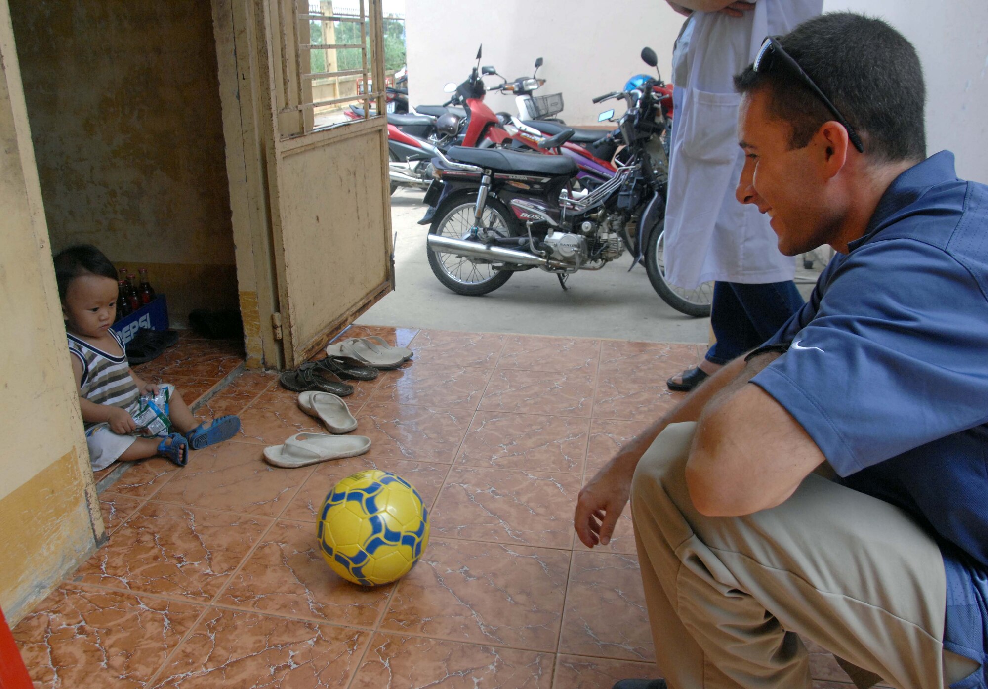 Special Agent Christopher Reilly, from Detachment 602 at Andersen Air Force Base, Guam, gives a soccer ball to a young Vietnamese child at the medical clinic set up at Truong Thanh, Vietnam as part of Pacific Angel 10-2. Operation Pacific Angel is a joint and combined humanitarian and civic assistance operation conducted in the Pacific area of responsibility to support U.S. Pacific Command's capacity-building efforts. More than 50 U.S. military members are working alongside the Vietnamese military, non-governmental organizations and civil health personnel in medical and engineering efforts during the mission scheduled through May 15. (U.S. Air Force photo/Capt. Timothy Lundberg)