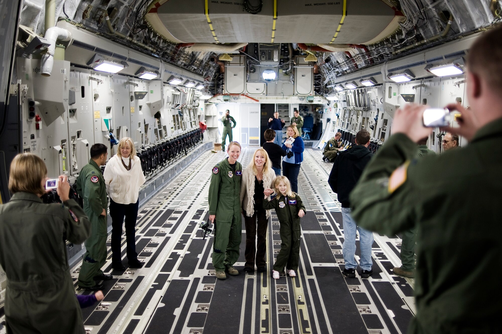 Pilot for a Day candidate Kaylie Bergen, age 6, and her mother Christy pause for a photo with 1st Lt. Eleanor Morgan, 4th Airlift Squadron, while touring a C-17 Globemaster III May 11 as part of McChord Field's Pilot for a Day program. (U.S. Air Force Photo by Abner Guzman)

