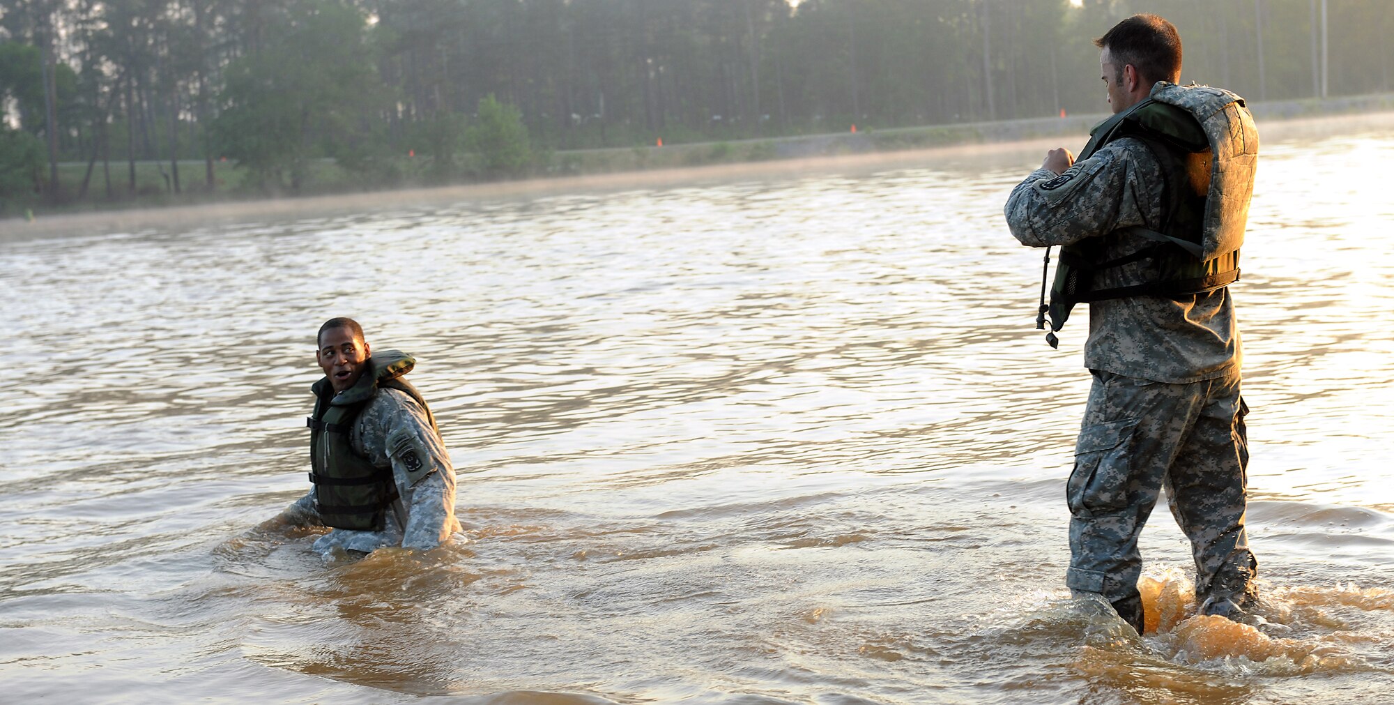 FORT BENNING, Ga. -- U.S. Army Sgt. 1st Class Cedric King and U.S. Army Staff Sgt. Rommel Hurtado, 199th Infantry Brigade, secure their life vests and swim through Victory Pond during the buddy run for the 27th annual David E. Grange Jr. Best Ranger Competition here May 7. The competition is a three-day event consisting of physical and mental tasks with several elimination rounds. (U.S. Air Force photo by Airman Class Joshua Green/RELEASED)