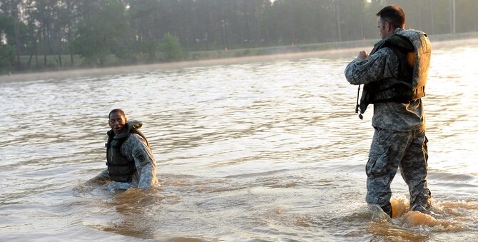 FORT BENNING, Ga. -- U.S. Army Sgt. 1st Class Cedric King and U.S. Army Staff Sgt. Rommel Hurtado, 199th Infantry Brigade, secure their life vests and swim through Victory Pond during the buddy run for the 27th annual David E. Grange Jr. Best Ranger Competition here May 7. The competition is a three-day event consisting of physical and mental tasks with several elimination rounds. (U.S. Air Force photo/Airman Class Joshua Green)