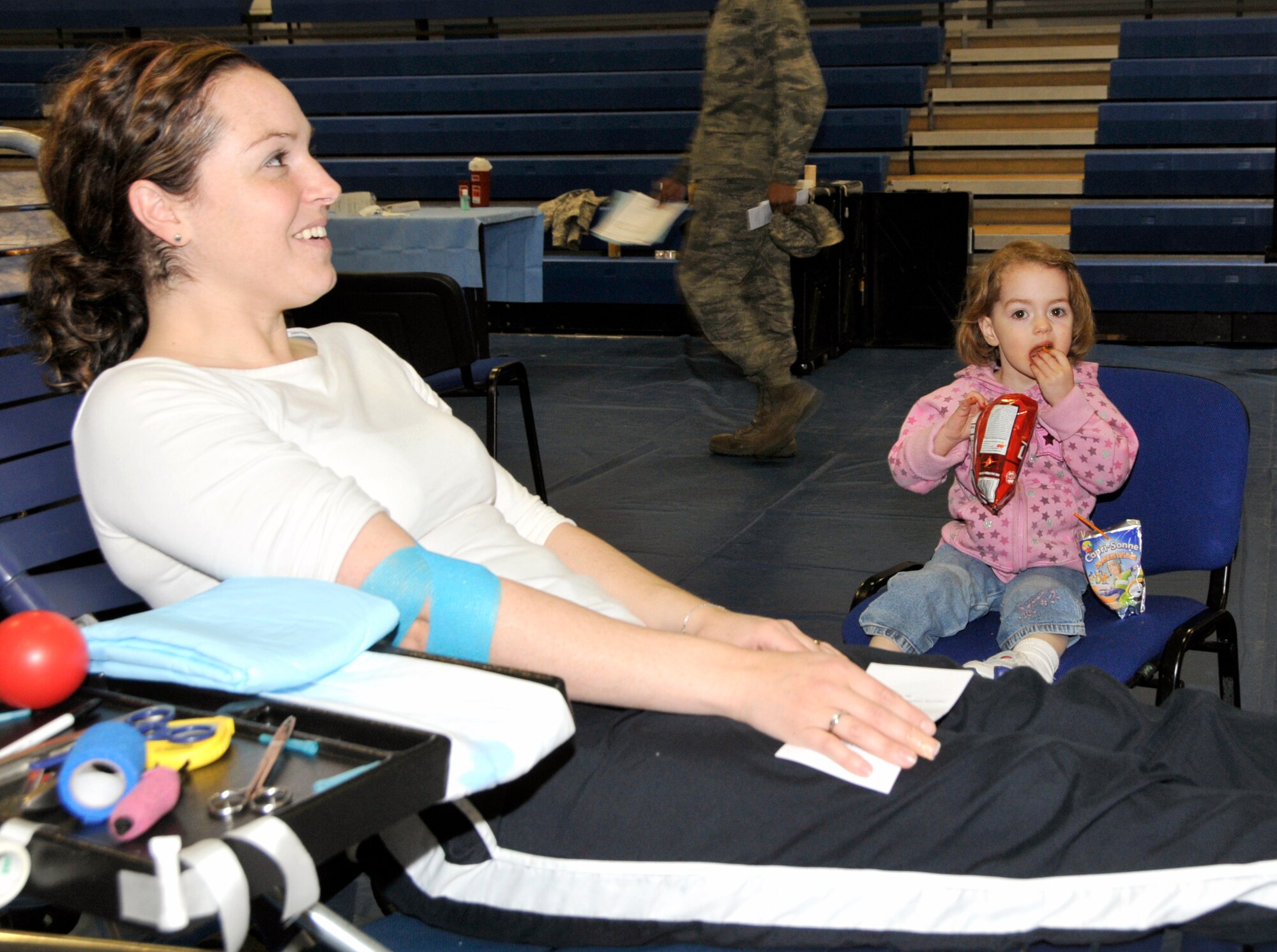 Brenda Johnson, wife of Tech. Sgt. Timothy Johnson 48th Component Maintenance Squadron assistant chief of moduler repair, relaxes after donating blood as her  daughter, Evelyn, 4, has a snack May 11. Personnel from near-by bases came out to donate for the Armed Services Bllod drive held at RAF Lakenheath, England. (U.S. Air Force photo/Airman 1st Class Eboni Knox)