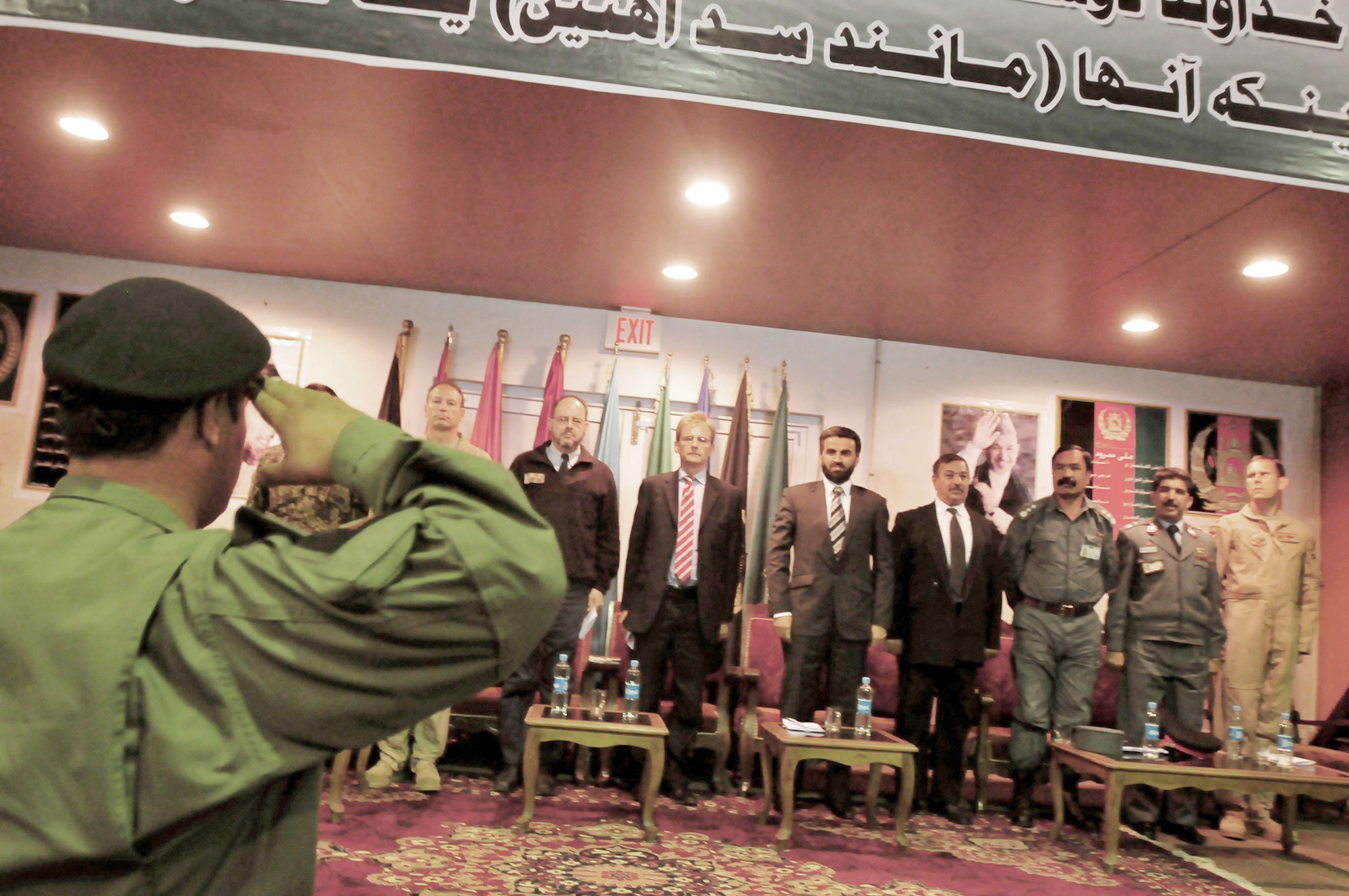 Afghan National Army Air Corps Col. Fahim Ramin salutes Tom Dodd (center) and Deputy Minister Daud (right-center) to conclude the transition ceremony May 5, 2010, at the conference center on a Afghan National Army Air Corps base in Kabul, Afghanistan. Colonel Ramin is the commanding officer of the Air Interdiction Unit. Mr. Dodd is the deputy ambassador to England. Mr. Daud is the deputy minister of counter narcotics for the ministry of interior. (U.S. Navy photo/Petty Officer 2nd Class David Quillen)
