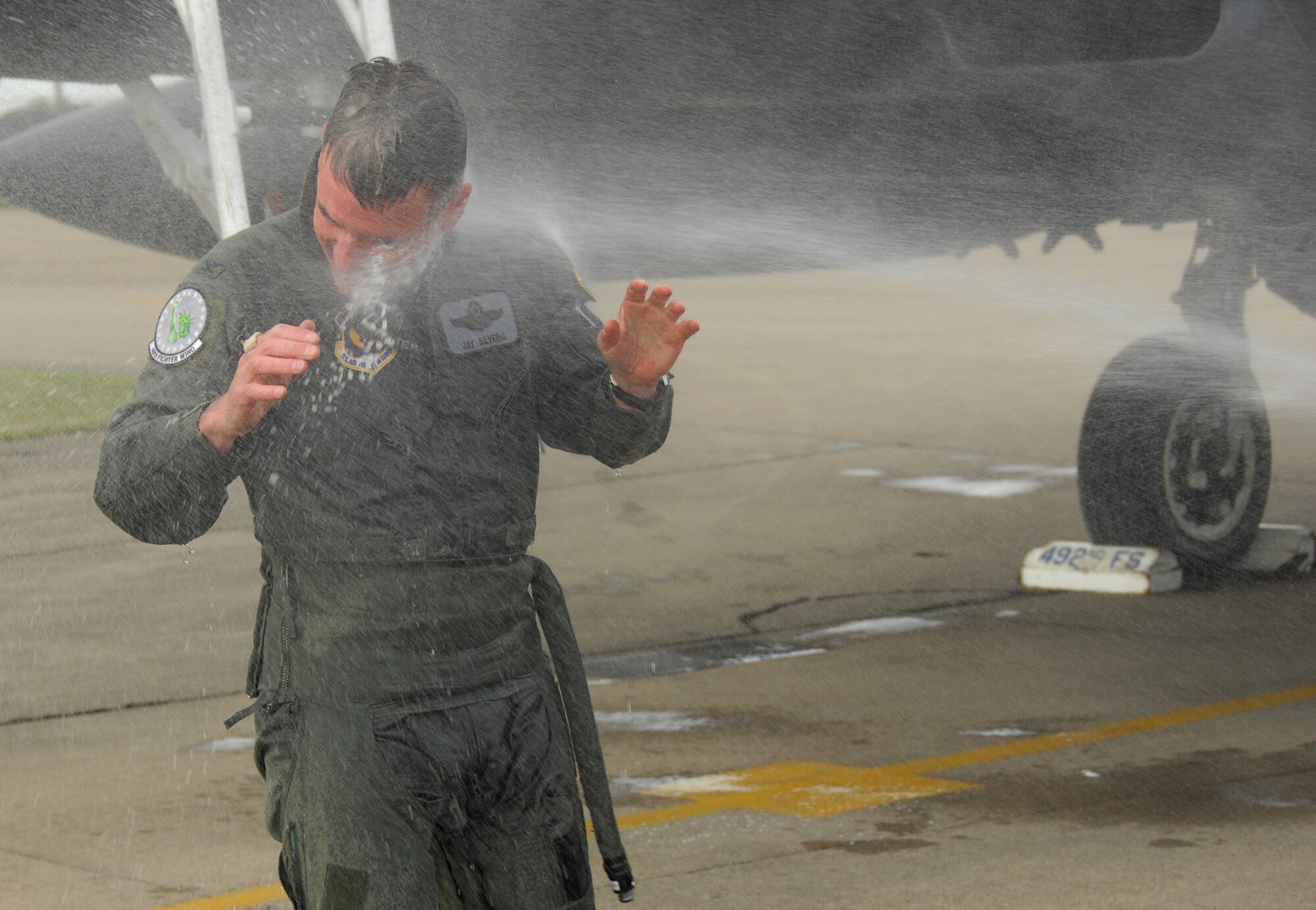Col. Jay Silveria, 48th Fighter Wing commander, is sprayed with water after completing his final flight as commander at RAF Lakenheath, England, May 13.  As is U.S. Air Force tradition, before aircrew permanently change duty stations, they fly their last flight and on return to the base are met and hosed with water by their squadron comrades before being toasted with champagne.  Colonel Silveria will depart England in June to become the Air Combat Command Inspector General at Langley Air Force Base, Va. (U.S. Air Force Photo by Tech. Sgt. Christopher Campbell)