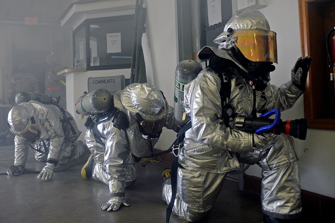 ELLSWORTH AIR FORCE BASE, S.D. – (Left to right) Senior Airman Craig George and Airmen 1st Class Taylor Messer and Mitch Carrell, 28th Civil Engineer Squadron firefighters, navigate their way through a simulated fire during a Phase II Operational Readiness Exercise, May 12. During the Phase II ORE, firefighters were tested on their ability to respond to and extinguish fires in a deployed environment. (U.S Air Force photo/Airman 1st Class Matthew Flynn)