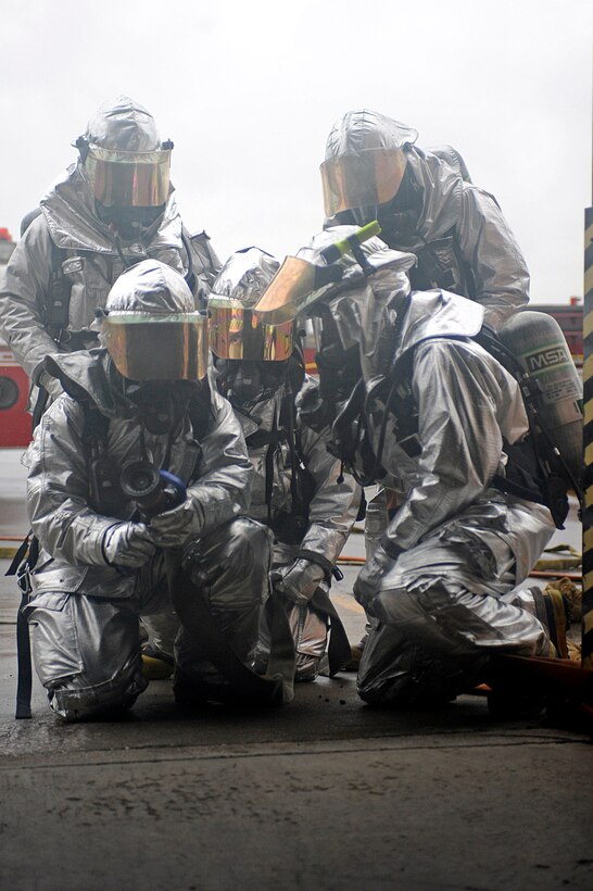 ELLSWORTH AIR FORCE BASE, S.D. -- Firefighters from the 28th Civil Engineer Squadron communicate the location of a simulated fire to one another during a Phase II Operational Readiness Exercise, May 12. The building was filled with non-toxic smoke to not only train Airmen on escaping, but to train firefighters on search and rescue tactics as well. (U.S. Air Force photo/Airman 1st Class Matthew Flynn)