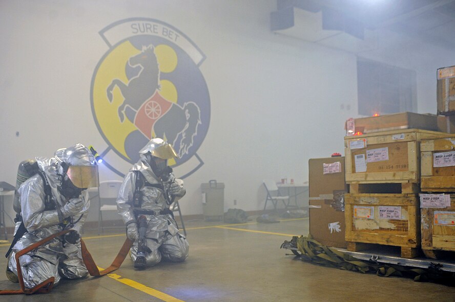 ELLSWORTH AIR FORCE BASE, S.D. – (Left) Senior Airman Alexander Gerszewski, 28th Civil Engineer Squadron firefighter, communicates to Senior Airman Kenneth Colton, 28 CES firefighter, during a Phase II Operational Readiness Exercise, May 12. The firefighters responded to a simulated structural fire on base. (U.S. Air Force photo/Airman 1st Class Matthew Flynn)