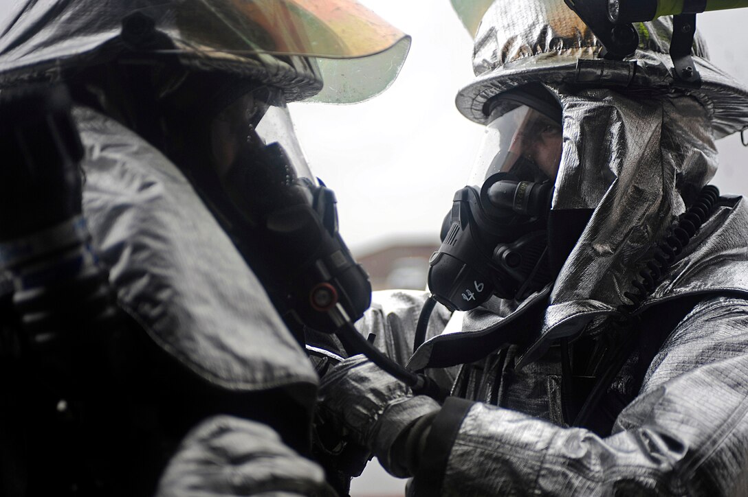 ELLSWORTH AIR FORCE BASE, S.D. – (Right) Senior Airman Alexander Gerszewski, 28th Civil Engineer Squadron firefighter, adjusts the helmet and gas mask of Senior Airman Kenneth Colton, 28 CES firefighter, during a Phase II Operational Readiness Exercise, May 12. The Phase II ORE is designed to mimic a deployed environment and test the combat abilities of Ellsworth’s Airmen. (U.S. Air Force photo/Airman 1st Class Matthew Flynn)
