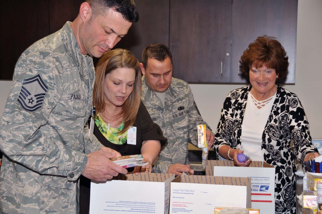 (Left to right) Senior Master Sgt. Peter Padilla, Air Force Operational Test and Evaluation Center First Sergeant, helps put together care packages for AFOTEC’s deployed members with Mrs. Brandi Miller, MSgt. Scott Miller, AFOTEC Superintendent of Executive Support, and AFOTEC Key Spouse Program leader Mrs. Vivie Sargeant. (Photo by George Diamond).