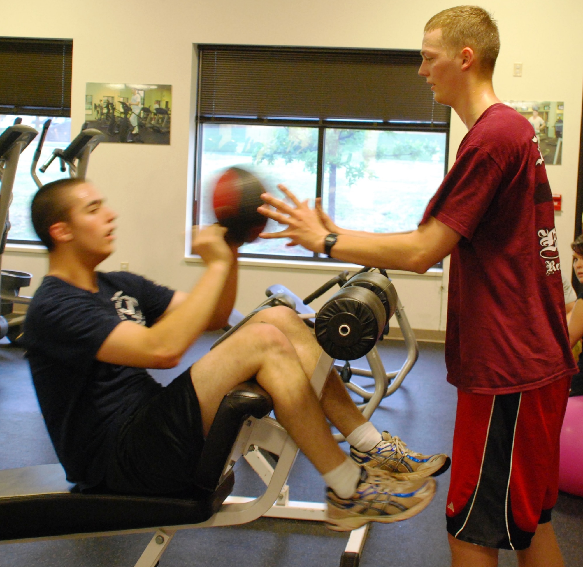 Airmen in Training from the 365th Training Squadron, Airman Josiah Perrin and Airman Ryan Clyde, stay in shape by training with an 8-pound medicine ball at the Pitsenbarger Fitness Center, Sheppard Air Force Base, Texas, May 12, 2010. The Air Force will switch to new physical fitness standards July 1, 2010. (U.S. Air Force photo/Airman 1st Class Valerie Hosea)