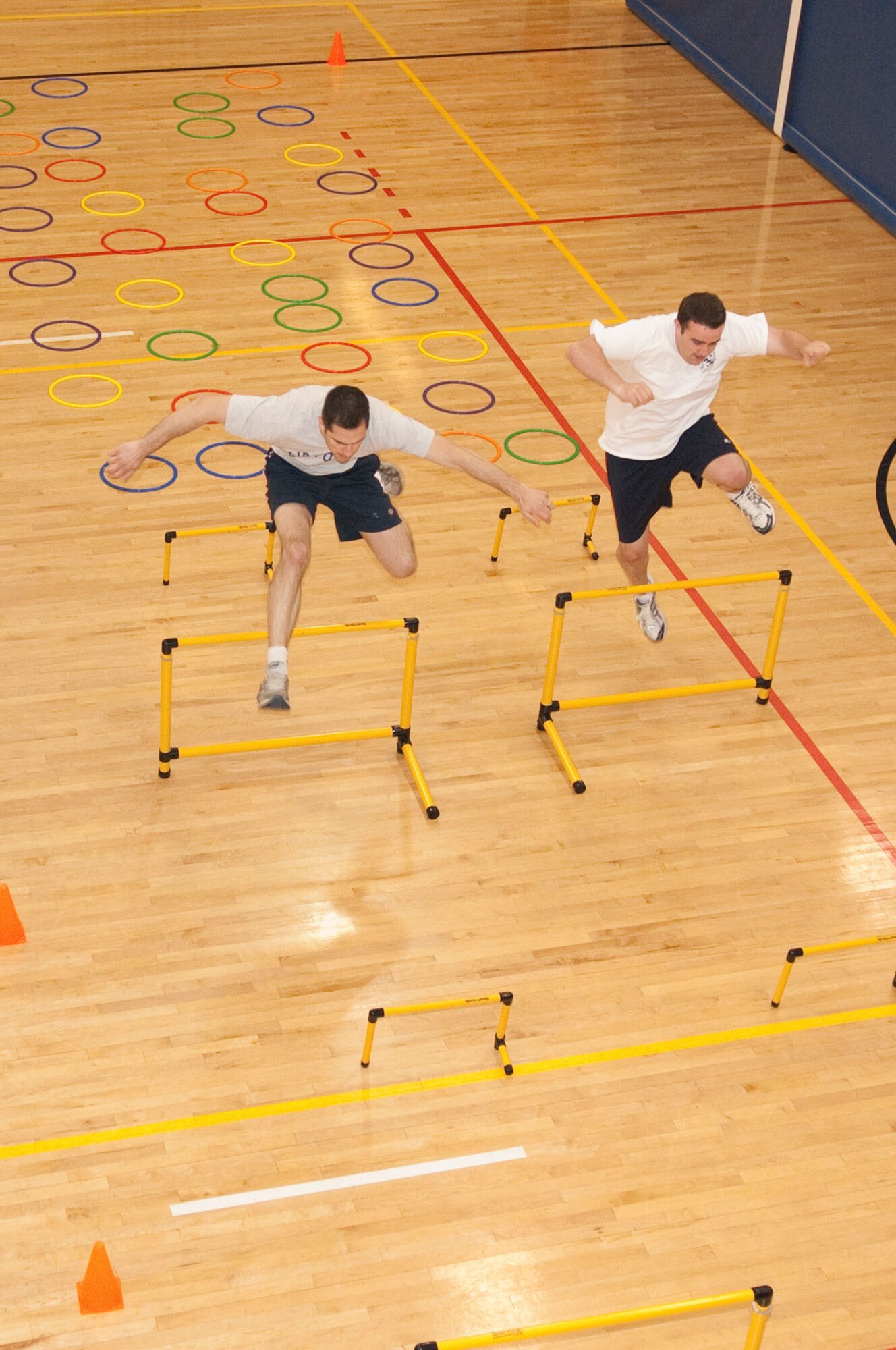 HANSCOM AIR FORCE BASE, Mass. – Mr. Sean Scanlon of the Electronic Systems Center (l) and Staff Sgt. Darron Barnhart from the 66th Medical Group clear hurdles during the obstacle course challenge on May 6. The obstacle course was one of many events that were a part of the Hanscom Olympics. (U.S. Air Force photo by Rick Berry)