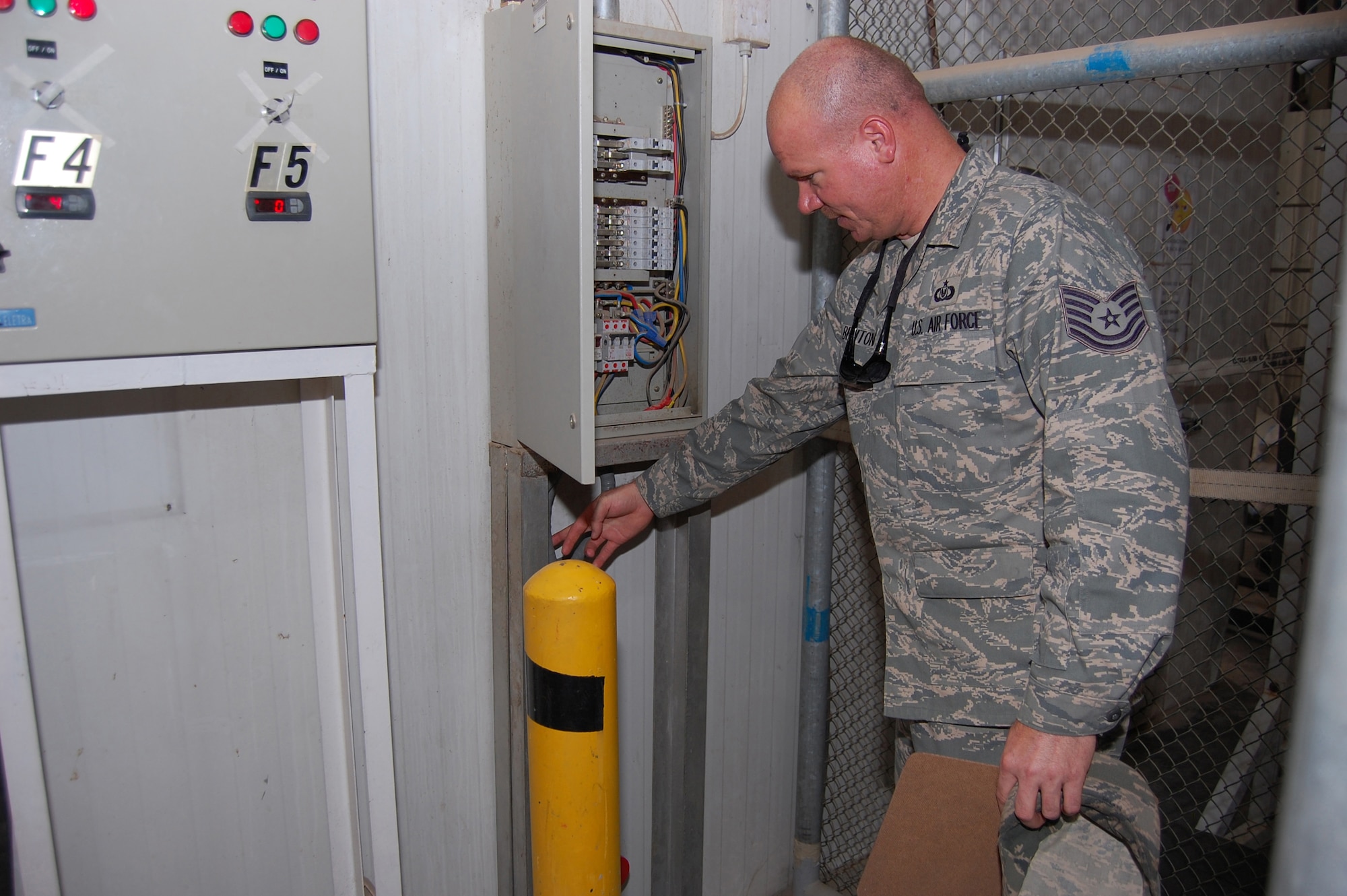 U.S. Air Force Tech. Sgt. Heath Benton, 386th Air Expeditionary Wing ground safety manager, inspects an electrical panel and its wiring during a follow-up facility inspection May 12, 2010 at an air base in Southwest Asia. Ground safety representatives conduct unit facility inspections annually in which they look for such issues as electrical hazards, egress hazards and unsafe conditions. (U.S. Air Force photo by Staff Sgt. Lakisha A. Croley/Released)