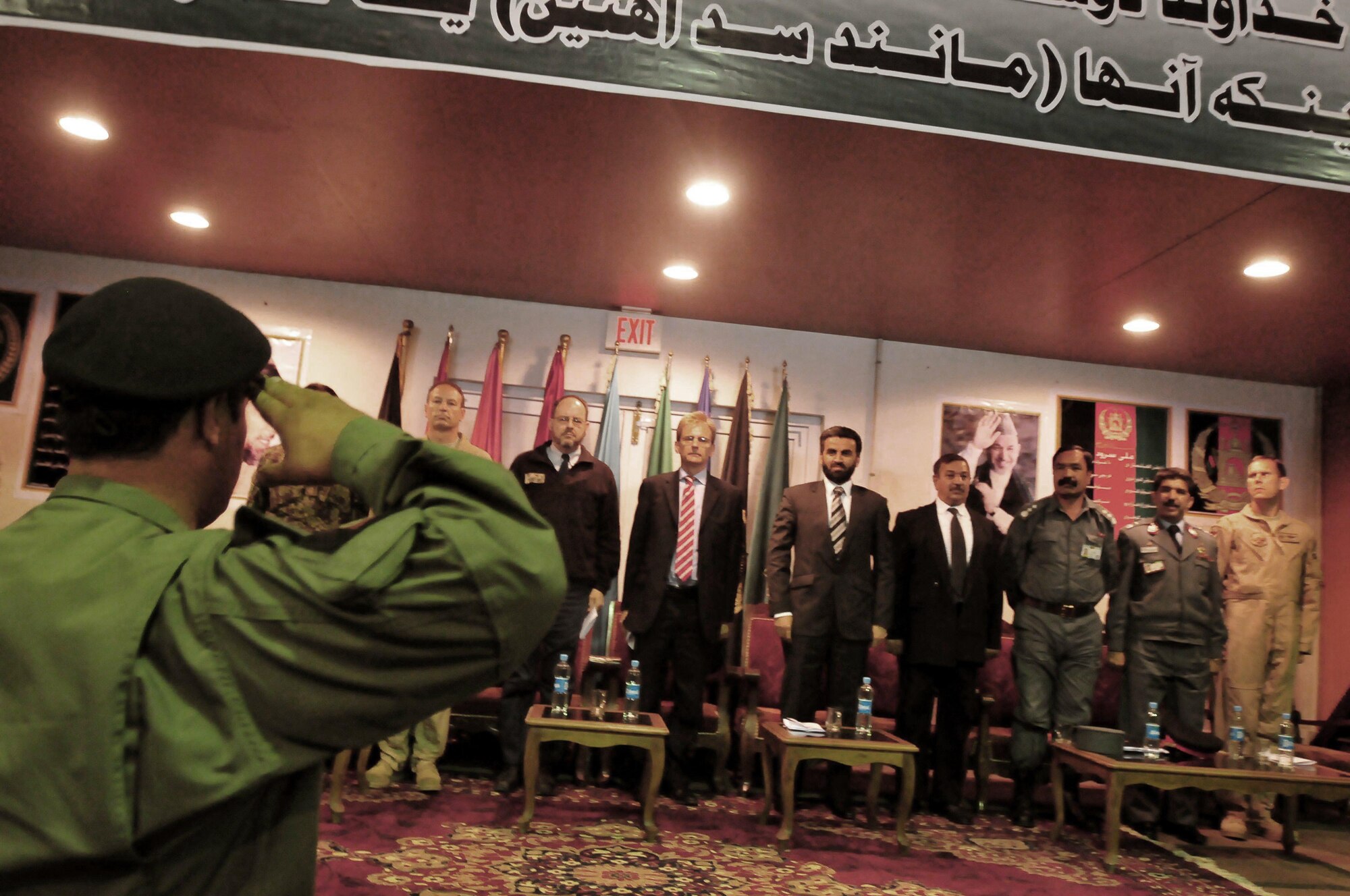 Afghan National Army Air Corps Col. Fahim Ramin, commanding officer, Air Interdiction Unit, salutes Mr. Tom Dodd, deputy ambassador to the United Kingdom, center, and Deputy Minister Daud, deputy minister counter narcotics, ministry of interior, right-center, to conclude the transition ceremony held at the conference center on the ANAAC base in Kabul, Afghanistan, May 5, 2010. The ceremony marked several achievements made by the AIU in the last 12 months. (U.S. Navy photo by Mass Communication Specialist 2nd Class David Quillen/ RELEASED)