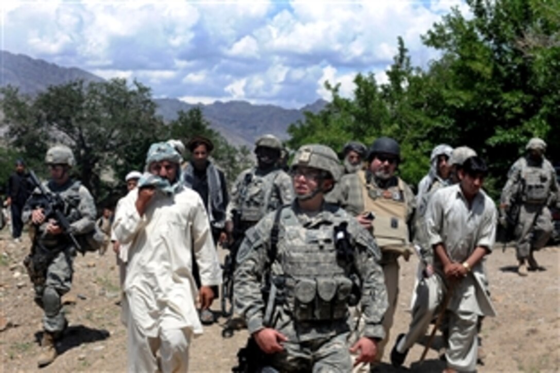 U.S. Army Spc. Justin Torres, center, and other members of the Parwan Provincial Reconstruction Team, walk with village elders, who were attending a shura, or counsel meeting, Parwan province, Afghanistan, May 9, 2010.