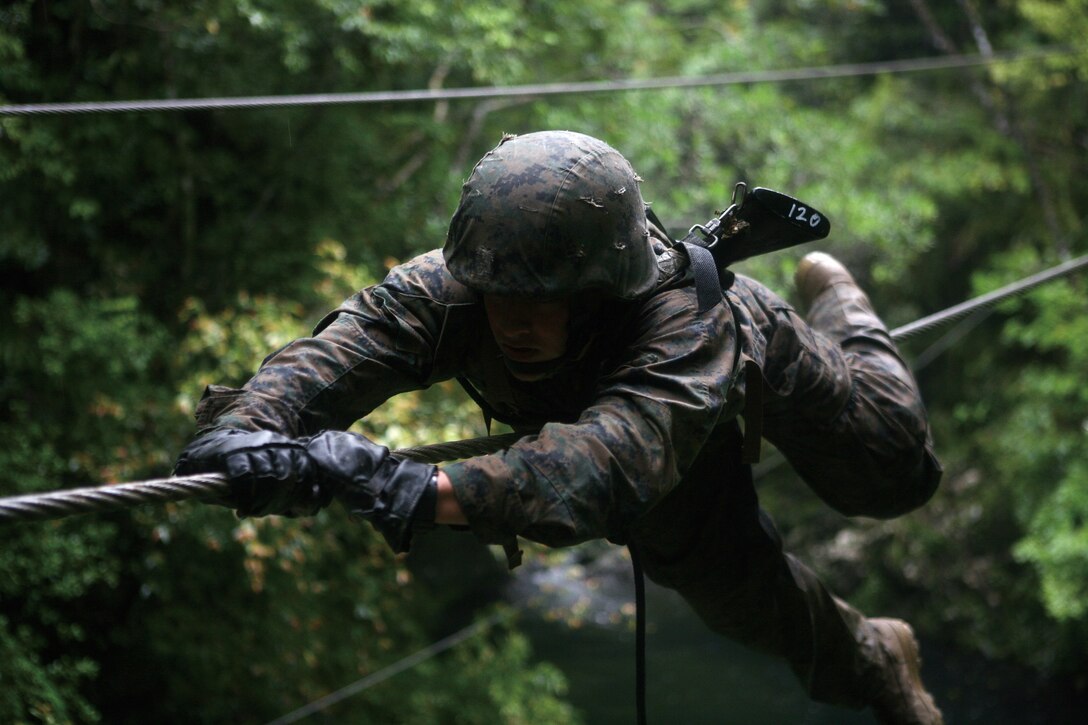 Lance Cpl. Sean Winton, a military policeman with Military Police Company, Headquarters Battalion, 3rd Marine Division, III Marine Expeditionary Force, pulls himself across the commando crawl obstacle during the six-day Jungle Skills Course at the Jungle Warfare Training Center May 14. The JWTC Jungle Skills Course provides Marines with skill sets for surviving in a jungle warfare environment.