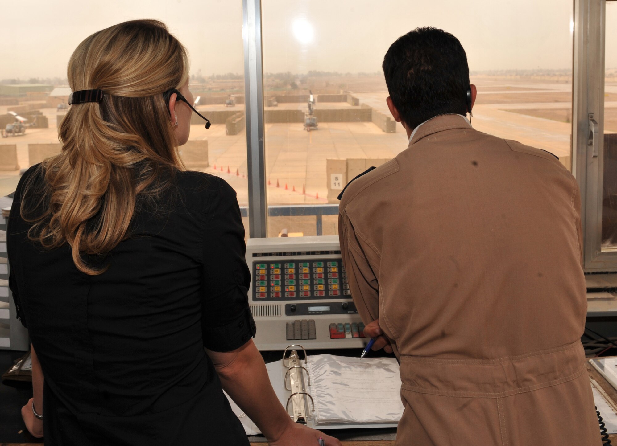 Air traffic control instructor Patsy Thomas and Iraqi air force 2nd Lt. Shorsh watch the flightline at Camp Taji, Iraq, from the air traffic control tower.  People from the Iraqi Training and Advisory Mission are in the process of transferring all operations to the Iraqi military.  Ms. Thomas is a member of the Washington Construct Group and is part of the transition team assisting in instructing future Iraqi air traffic controllers.  (U.S. Air Force photo/Staff Sgt Quinton Russ)