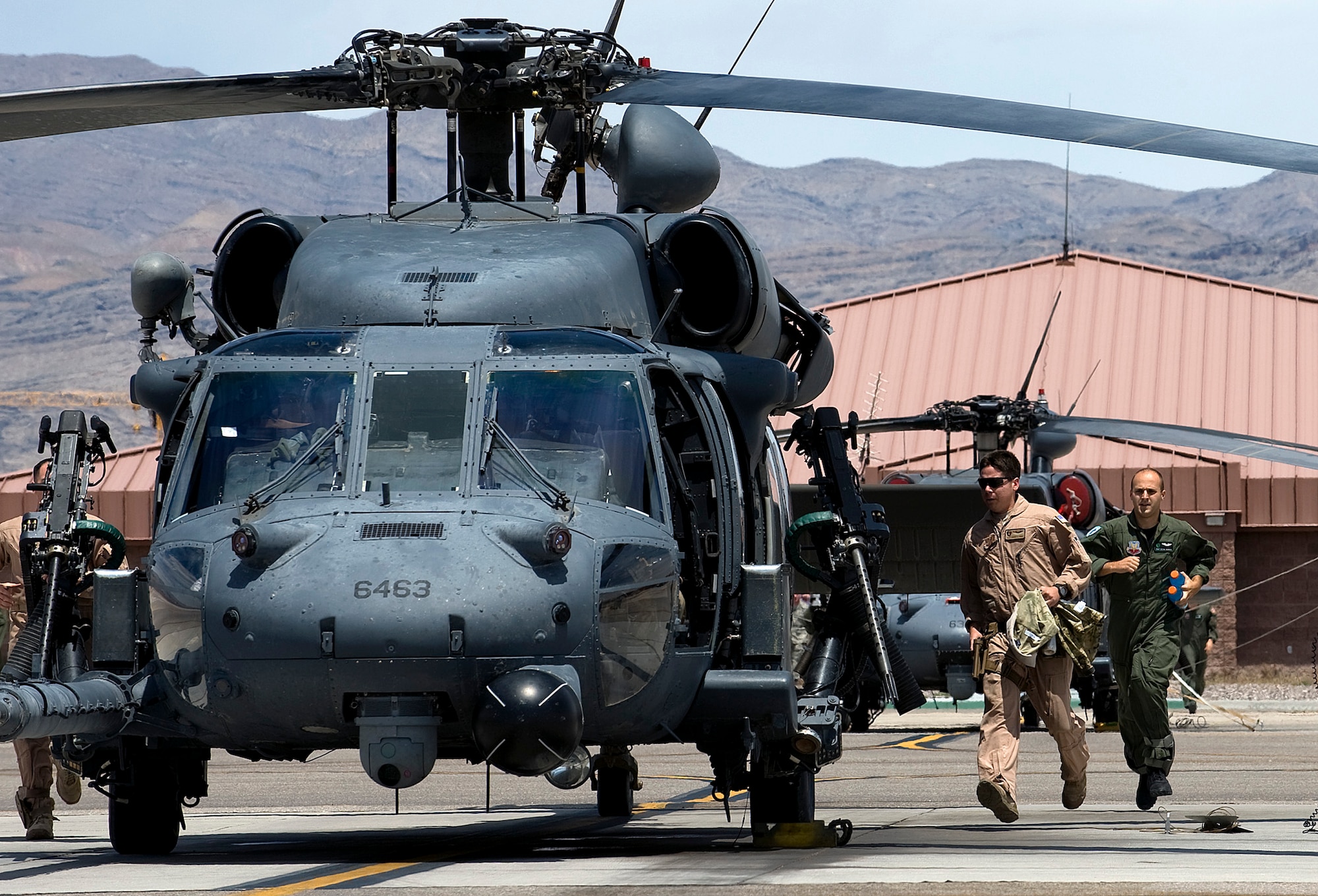 NELLIS AIR FORCE BASE, Nev. -- (left to right) Staff Sgt. Andres Ponce, Pararescueman assigned to the 66th Rescue Squadron, and Staff Sgt. Kevin Darosa, Aerial Gunner assigned to the 66th RQS, run to a HH-60G Pavehawk for a scramble exercise at the Nellis flight line, May 13. The primary mission of the 66th Rescue Squadron is to provide rapidly deployable, expeditionary combat search and rescue forces to theater commanders in response to contingency operations worldwide. (U.S. Air Force Photo by Airman 1st Class Brett Clashman)