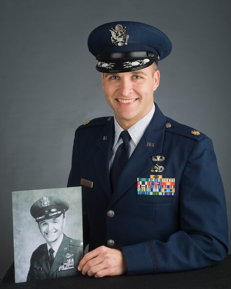 Maj. Gregory Kuzma, 62nd Aerial Port Squadron deputy commander, McChord Field, Joint Base Lewis-McChord, holds an official photo of his father Lt. Col. (ret.) Myron L. Kuzma, USAF.  (U.S. Air Force Photo by Abner Guzman)