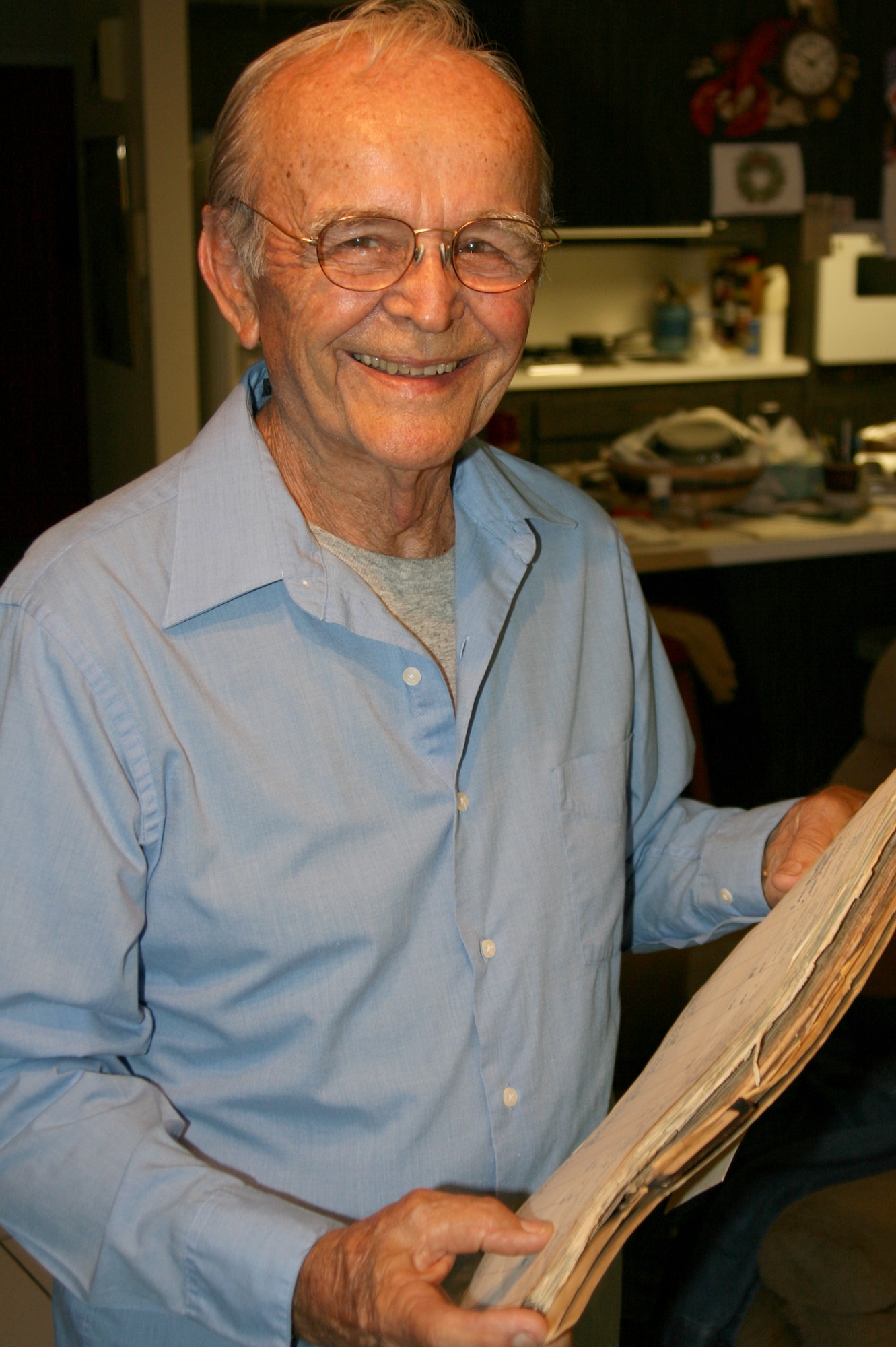 Lt. Col. (ret.) Myron L. Kuzma, USAF, holds log books from his missions as a member of the 7th Troop Carrier Squadron under the 62nd Troop Carrier Wing at McChord Air Force Base in the early 1950's. (Courtesy photo)

