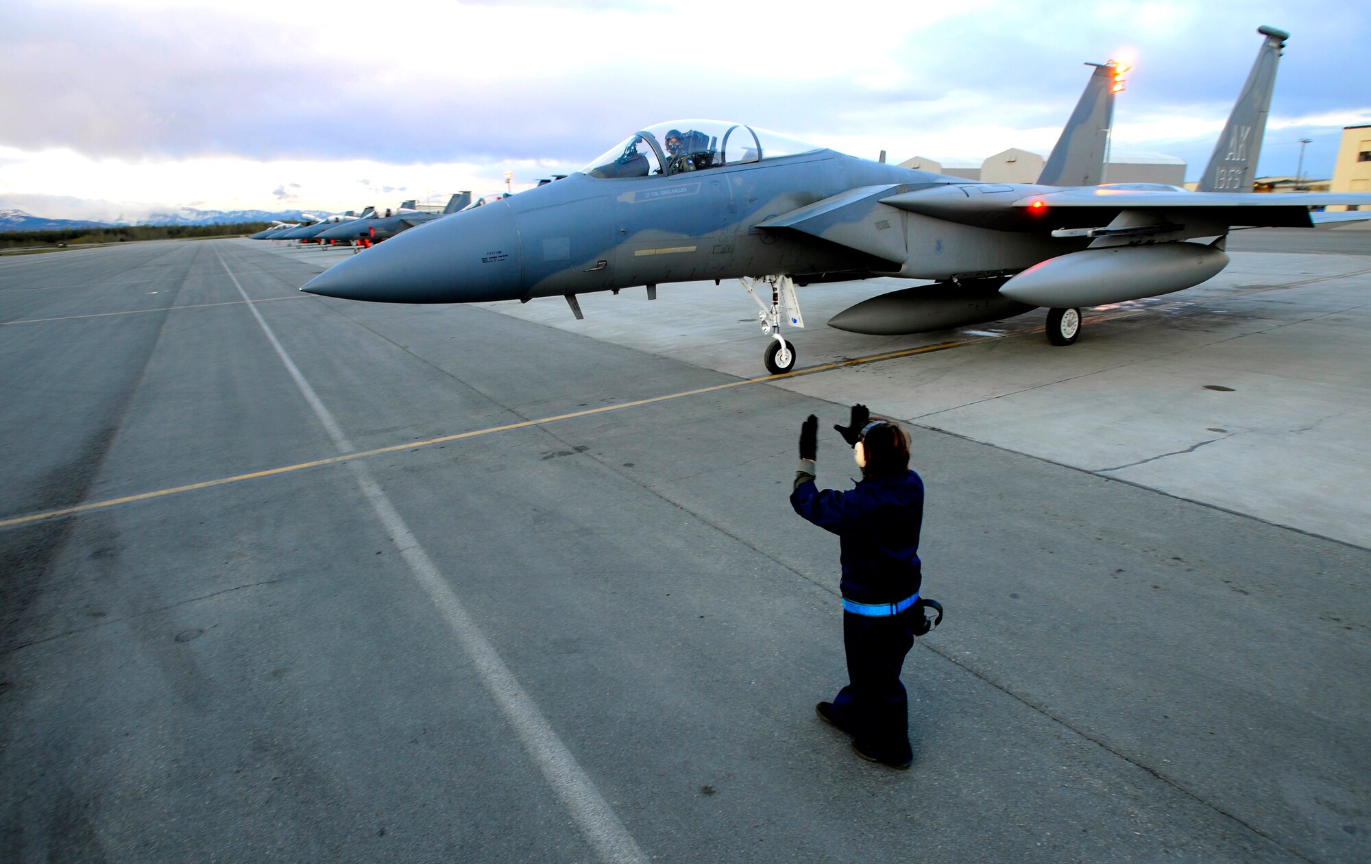 Staff Sgt. Sarah Flagg marshals the 19th Fighter Squadron's F-15 Eagle flagship before its final takeoff at Elmendorf Air Force Base, Alaska, May 13. The aircraft is going to the depot at Robins Air Force Base, Ga., for refurbishing then reassignment. Sergeant Flagg is a crew chief with the 3rd Aircraft Maintenance Squadron. (Air Force photo by Staff Sgt. Brian Ferguson)