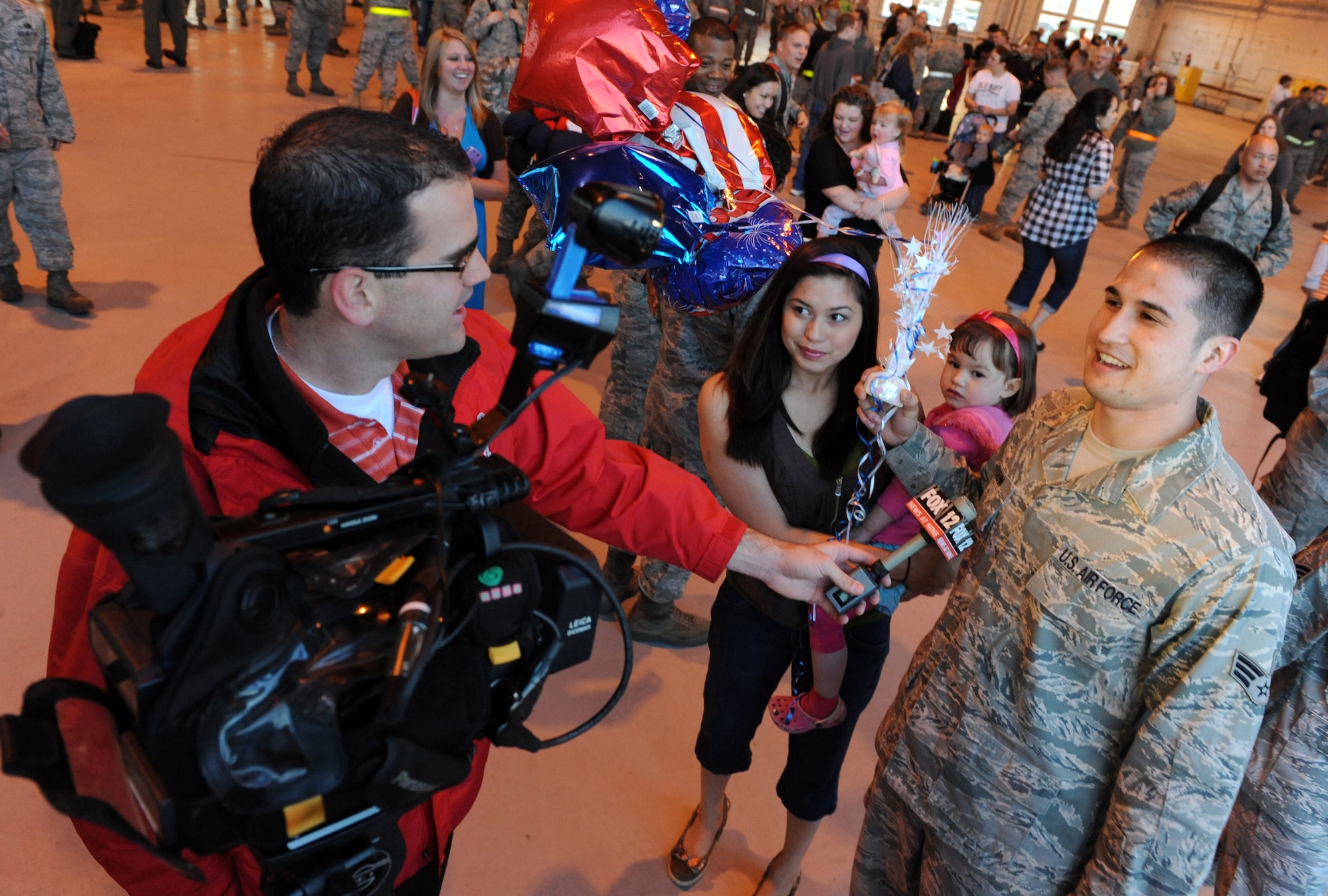 MOUNTAIN HOME AIR FORCE BASE, Idaho – Fox Channel 12 News Broadcaster interviews Senior Airman Phillip Kolehn, of the 391st Air Craft Maintenance Squadron, after his return from deployment May 14. His sister Christina Kolehn and niece Nevayah met him as he returned from a rotational deployment in support of U.S. Central Command and U.S. Pacific Command. (U.S. Air Force photo by Airman 1stClass Debbie Lockhart)