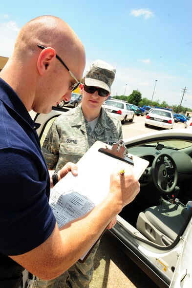 BARKSDALE AIR FORCE BASE, La. –Trooper Jason Kelly, Louisiana State Police fills out a child safety seat check-list for Senior Airman Jennifer Guyne, 2d Medical Operations Squadron mental health technician, following her car seat inspection May 12. Members from Louisiana State Police Department Troop G came out to help inspect child car seats and instruct parents on proper installation. (U.S. Air Force photo by Senior Airman Joanna M. Kresge)