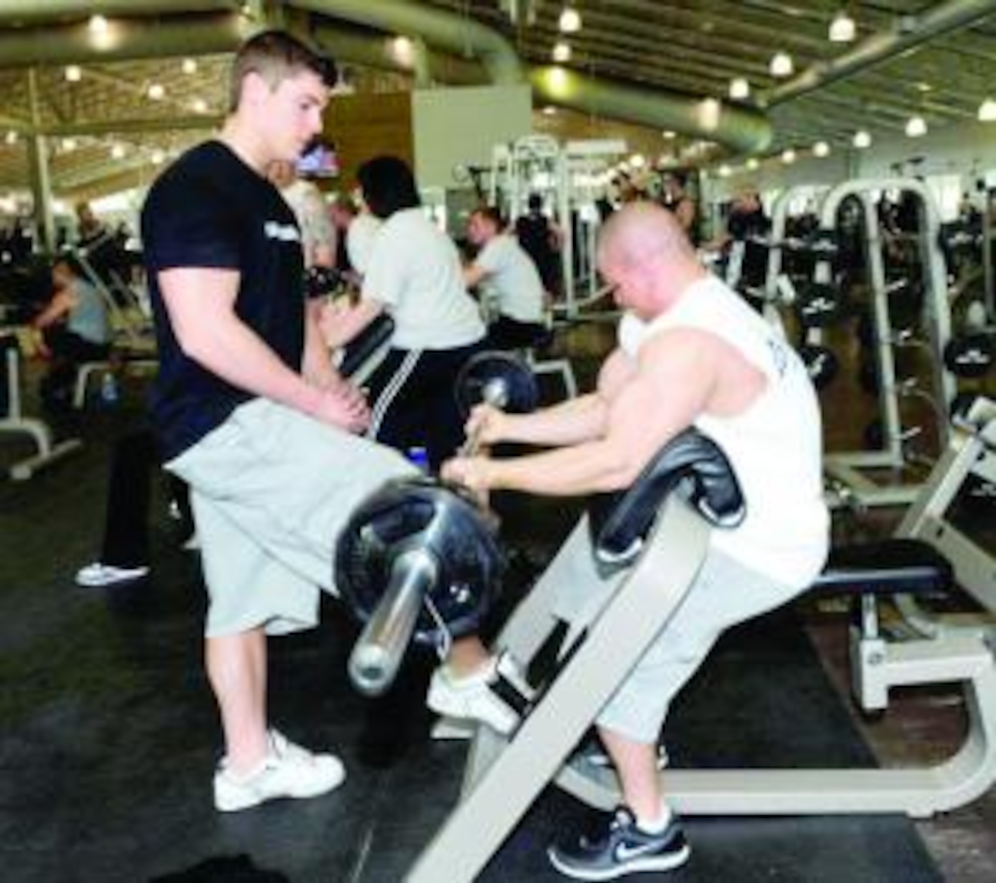 Dustin Biegenwald works out with his roommate/lifting buddy Shane Alexander Stewart at the Warrior Health and Fitness Center on May 5. He credits his family, roommates, the staff at the fitness center and his girlfriend for helping him to succeed in winning the open class middleweight title at the recent competition. (U.S. Air Force photo by Kim Cook)