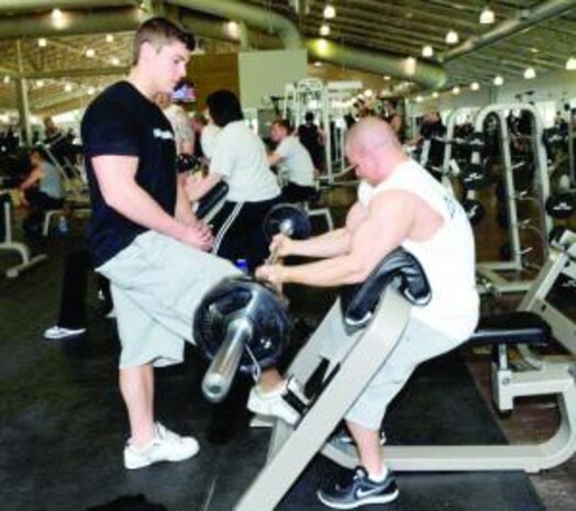 Dustin Biegenwald works out with his roommate/lifting buddy Shane Alexander Stewart at the Warrior Health and Fitness Center on May 5. He credits his family, roommates, the staff at the fitness center and his girlfriend for helping him to succeed in winning the open class middleweight title at the recent competition. (U.S. Air Force photo by Kim Cook)