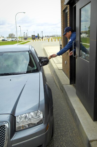 MINOT AIR FORCE BASE, N.D. -- Joe Hernandez, Chenega Security security officer contracted with the 5th Security Forces Squadron, checks a members ID as they pass through the Magic City Gate here May 13. Base security is paramount for the success of both the 91st Missile Wing and 5th Bomb Wing’s missions. (U.S. Air Force photo by Senior Airman Benjamin Stratton)