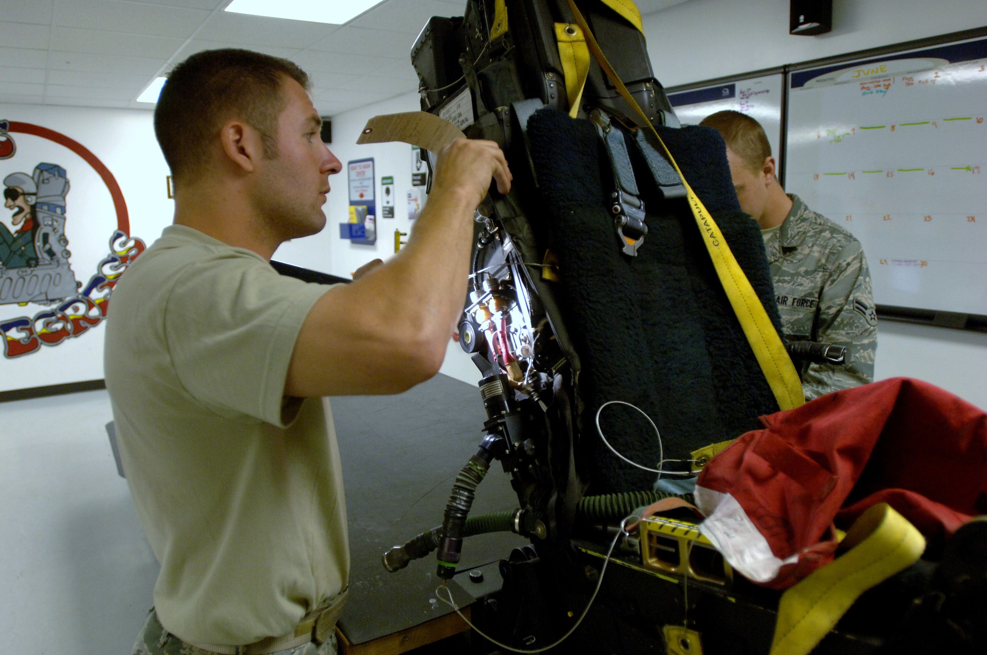 LANGLEY AIR FORCE BASE, Va. -- Staff Sgt. Ronald Kavanaugh, 192d Fighter Wing egress technician, and Airman 1st Class William Stanton, 1st Component Maintenance Squadron egress apprentice, inspect an Advanced Concept Ejection Seat II ejection system from an F-22 Raptor May 12. Each system undergoes an egress final inspection every 30 days, in which technicians physically inspect every component of the system they can touch. (U.S. Air Force photo/Airman 1st Class Jason J. Brown)