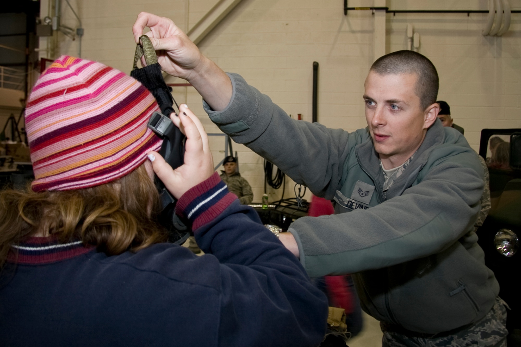 GRISSOM AIR RESERVE BASE, Ind. -- Working at a National Police Week education fair held here, Staff Sgt. Dustin Devine helps Kendra Kraning put on a gas mask. Sergeant Devine is a member of the 434th Security Forces Squadron and Ms. Kraning is a member of a 6th grade class at North Miami Middle/High School. The event, which was held May 11, featured federal, state and local law enforcement agencies. National Police Week starts on May 9 and culminates with National Peace Officer Memorial Day on May 15. (U.S. Air Force photo/Tech. Sgt. Mark R. W. Orders-Woempner)