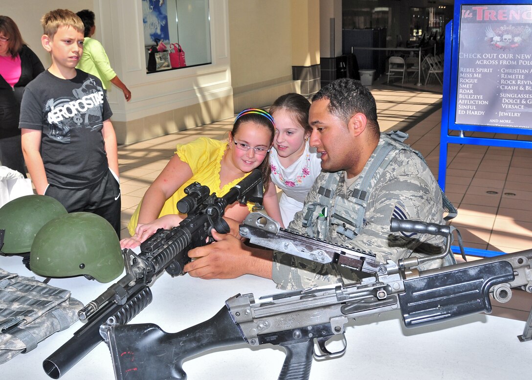 U.S. Air Force Staff Sgt. Joseph Marie of the 914th Security forces shows Ireland Johnston of Brantford Ontario, how to look site a weapon while Chris and his sister Tara Johnson wait their turn, May 14, 2010, Niagara Factory Outlet Mall, Niagara Falls NY. Niagara Falls Air Reserve Station 914th Security Forces along with other local Police Agencies as well as Canadian Authorities will be celebrating Police Week on Friday, May 14th and Saturday, May 15th, 2010 at Fashion Outlets Niagara Falls USA. (U.S. Air Force photo by Staff Sgt. Joseph McKee)