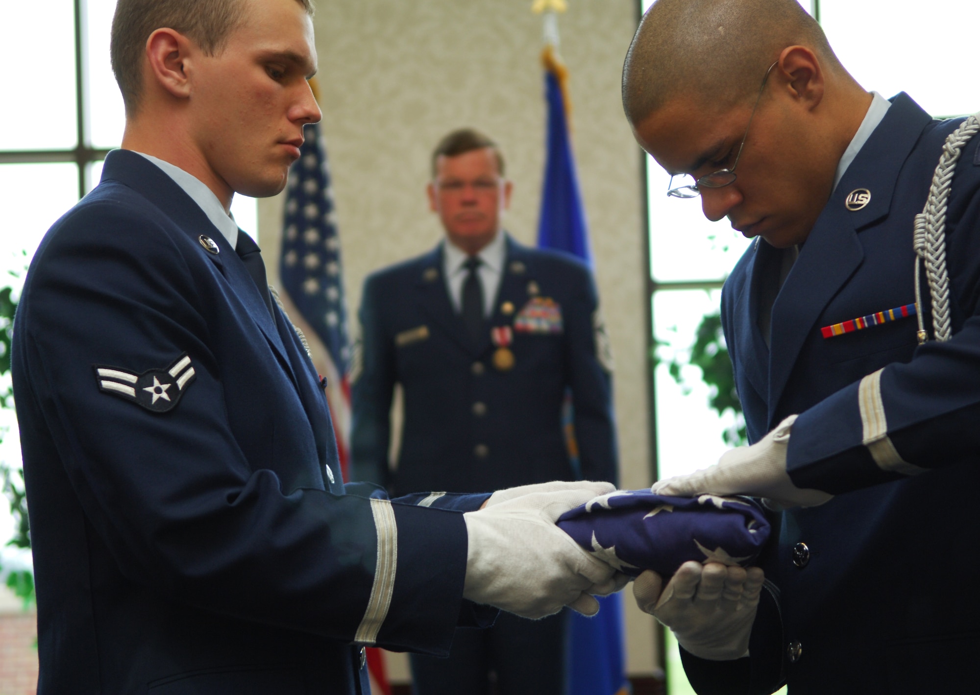 SCOTT AIR FORCE BASE, Ill. -- Two members of the base honor guard fold the flag at a retirement ceremony for Chief Master Sgt. Jim Suttles, former 375th Air Mobility Wing command chief, May 12. (U.S. Air Force by Senior Airman Samantha Crane)