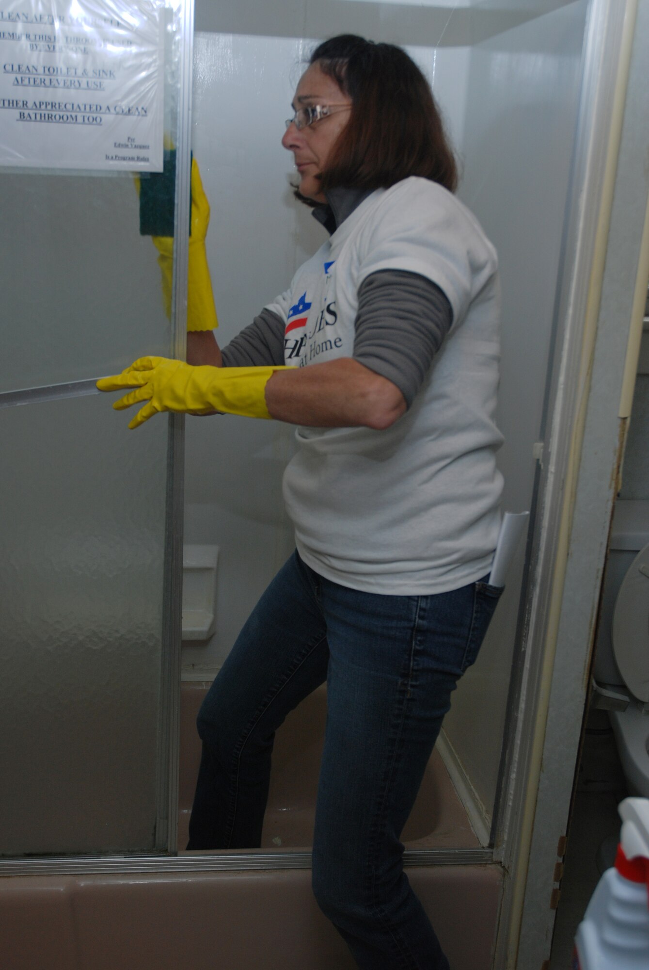 Master Sgt. Michelle Dunfield, 337th Airlift Squadron first sergeant, cleans a bathroom inside of a 12-person veterans transition housing unit in Springfield.  Airmen from the 439th Airlift Wing and the 104 Fighter Wing teamed up with Rebuilding Together in Springfield for a one-day remodel of the home.