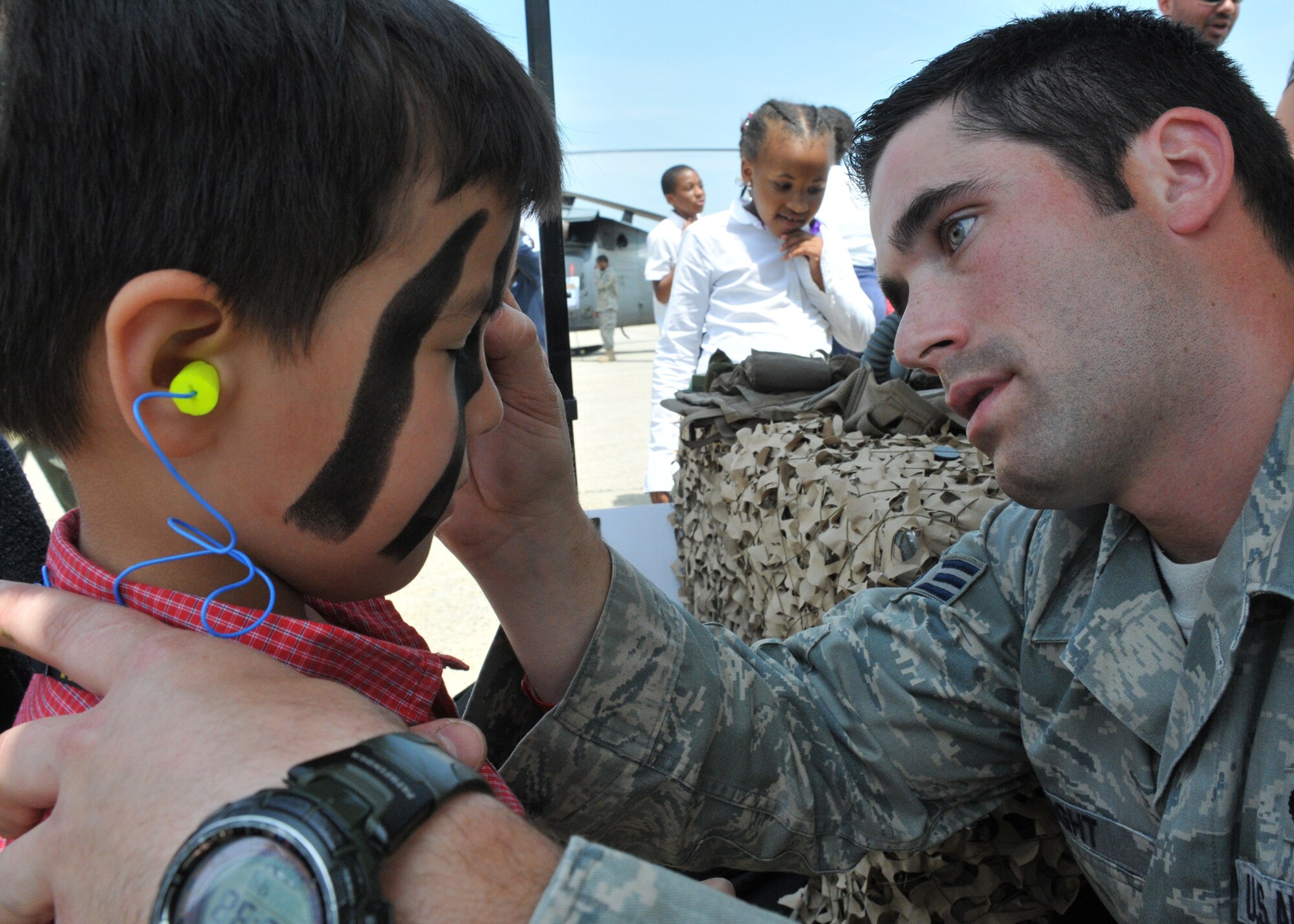 JOINT BASE ANDREWS, Md. -- Senior Airman Freddie Knight, 38th Rescue Squadron, Moody Air Force Base, Ga., Survival Evasion Resistance Escape specialist, paints the face of Jacob, 4-years-old, son of Matt Brown, Dyncorp C-21 mechanic. The SERE specialists are scheduled to display their equipment and greet patrons May 15 and 16. The 2010 Andrews Air Show is free and open to the public from 8 a.m. to 5 p.m. (U.S. Air Force photo by Airman 1st Class Kat Lynn Justen)