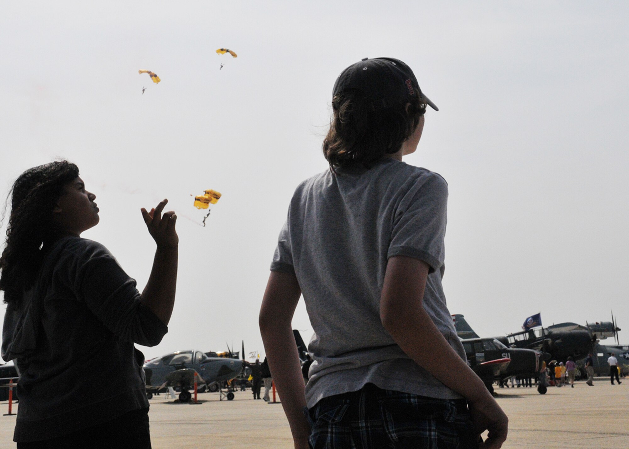JOINT BASE ANDREWS, MD. -- Patrons look on as the Army Golden Knight parachute team performs here May 14. The Golden Knights jumped from a C-31A Friendship and conducted aerial maneuvers during their free fall. They are scheduled to perform again May 15 and 16. The 2010 Andrews Air Show is free and open to the public from 8 a.m. to 5 p.m. (U.S. Air Force photo by Airman 1st Class Kat Lynn Justen)