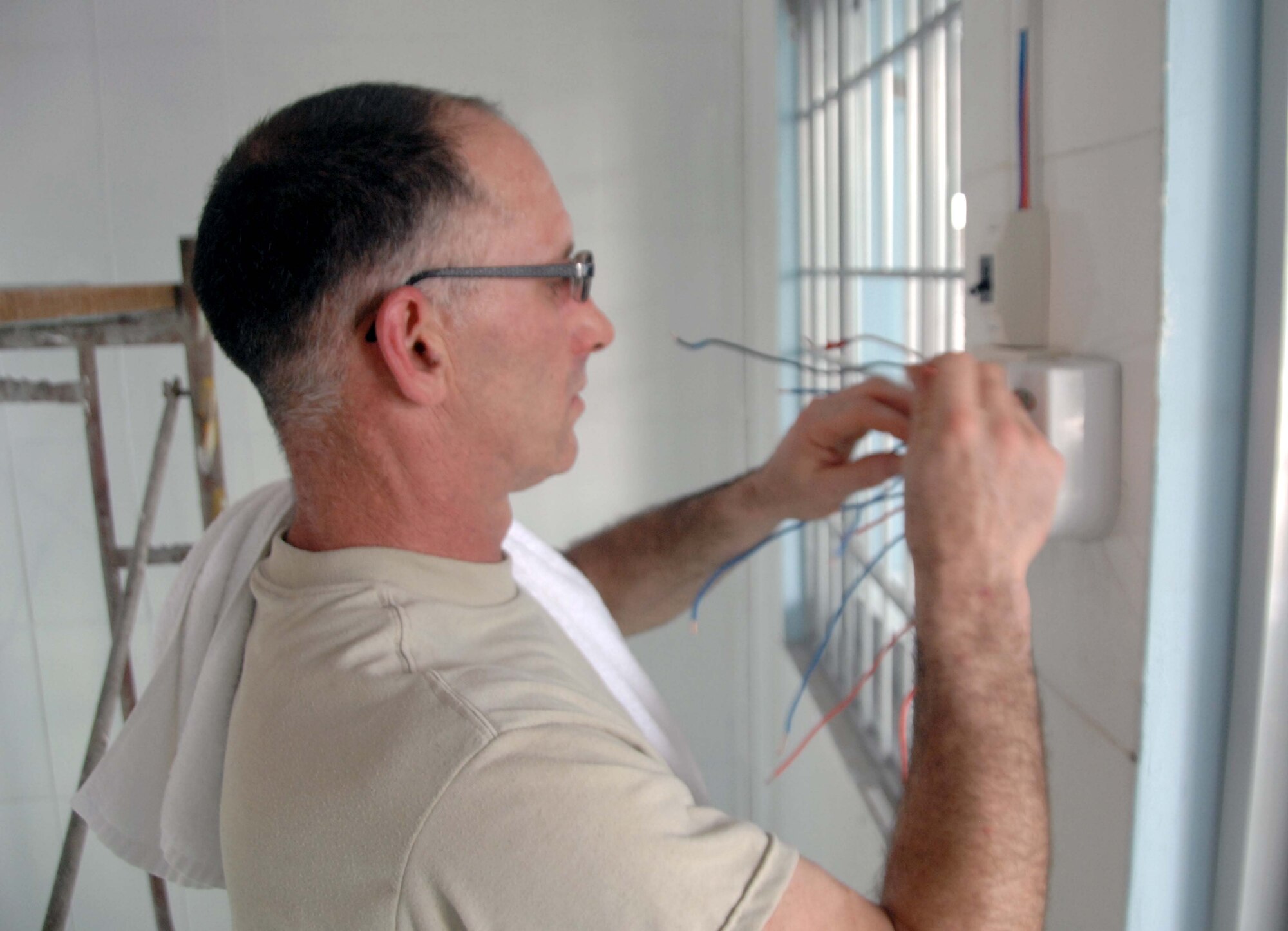 Master Sgt. John Swearingin works on an electrical wiring box at the village medical clinic at Truong Thanh, Vietnam, May 11, 2010, as part of an engineering project for Pacific Angel 10-2. Sergeant Swearingin is from the Alaska Air National Guard's 176th Civil Engineer Squadron in Anchorage. (U.S. Air Force photo/Capt. Timothy Lundberg)